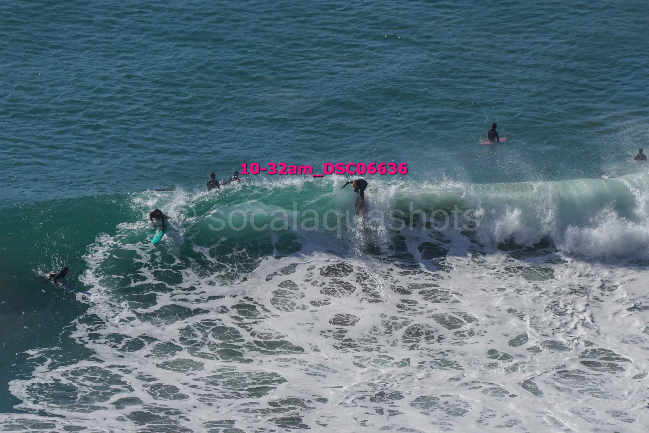 Surfers riding and waiting for waves in the ocean.