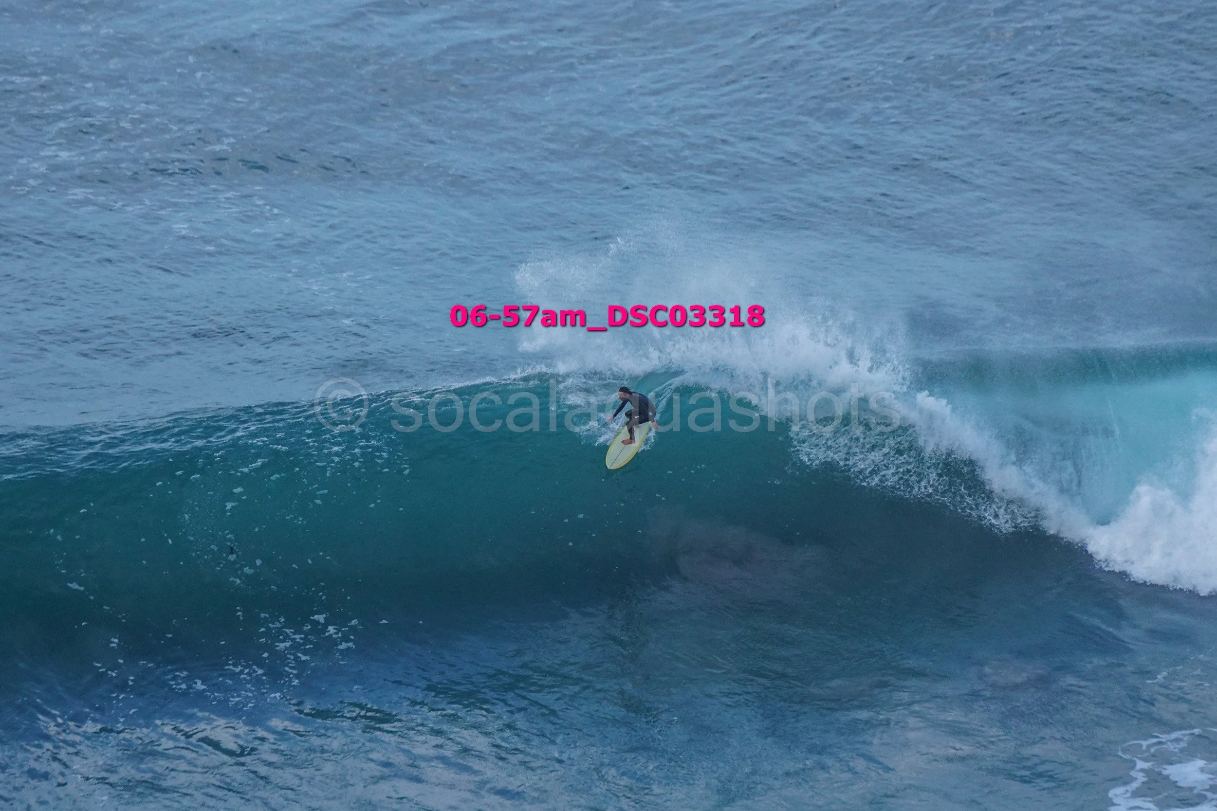 Surfer riding a wave in the ocean with spray and foam.