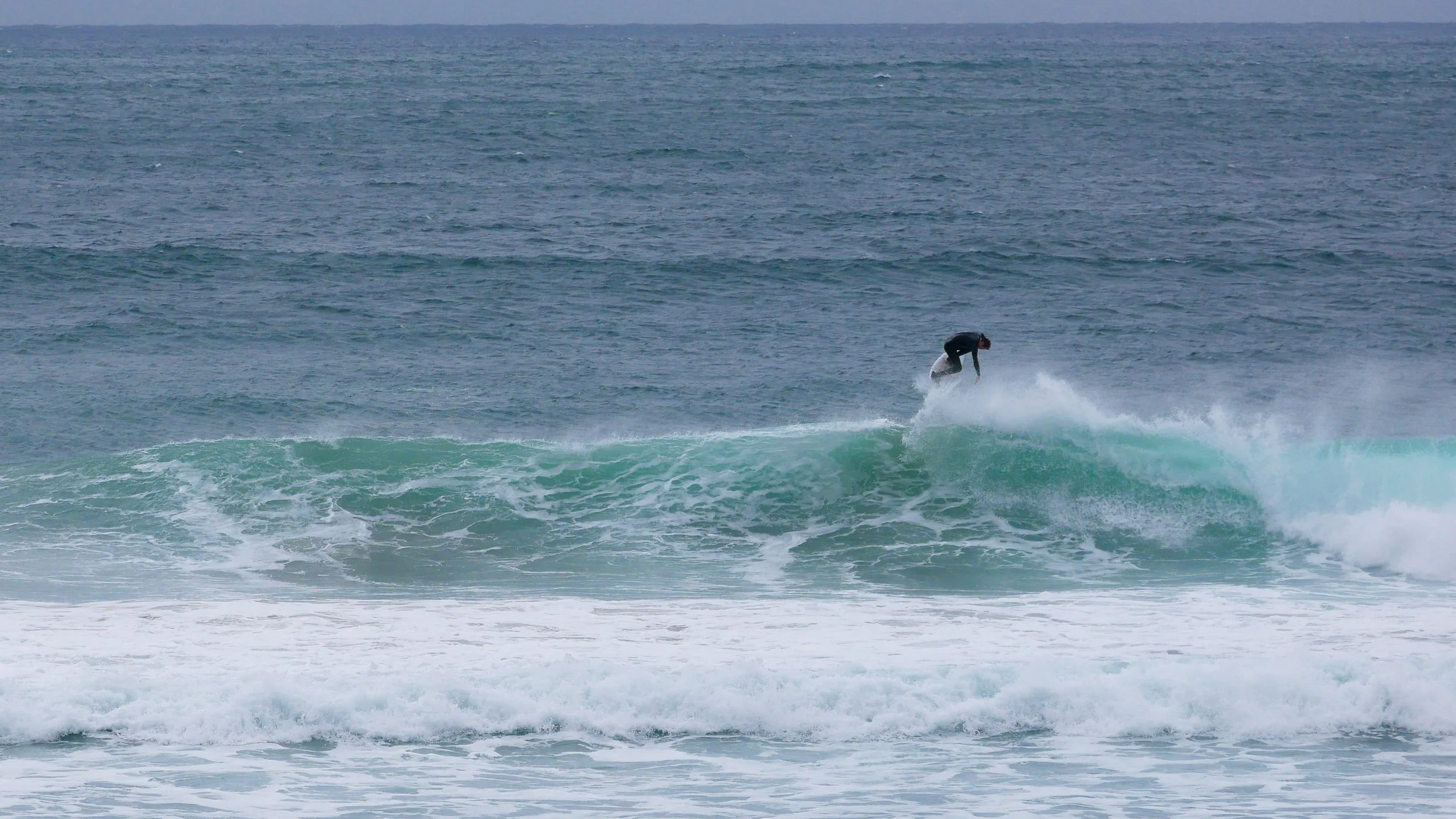 Surfer performing an aerial trick on a wave.