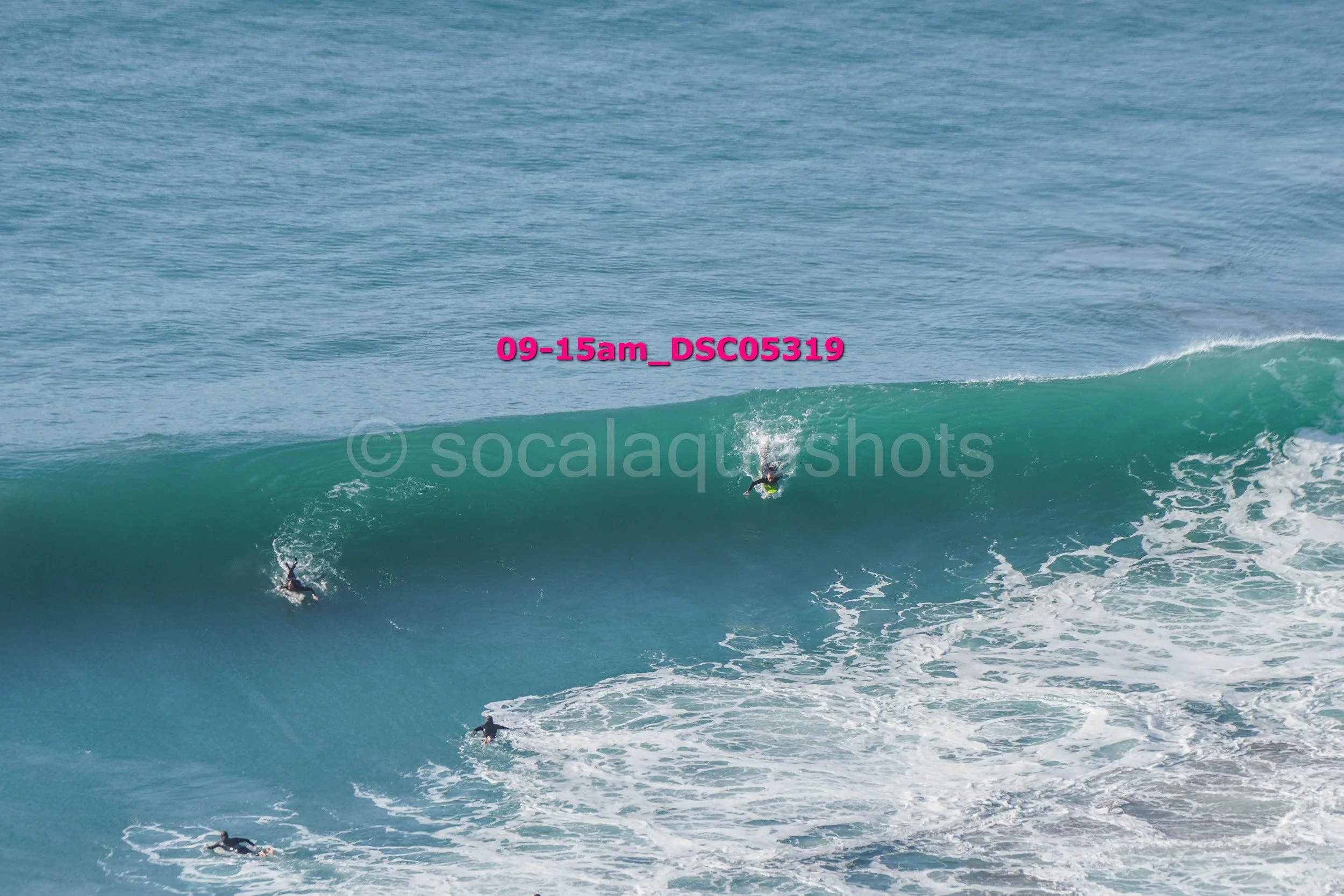 Multiple surfers riding and paddling on ocean waves in the water.