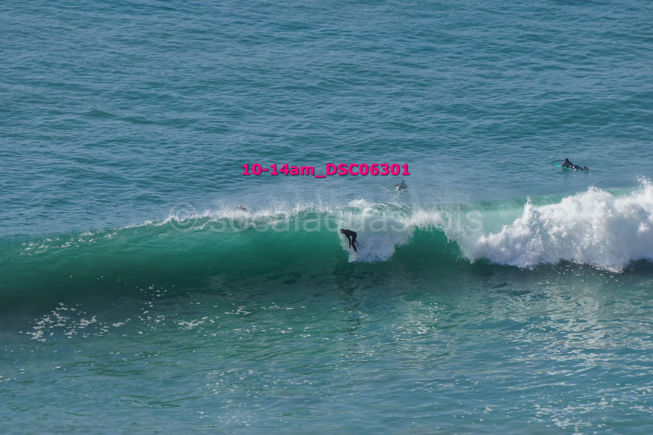 Surfer riding a wave with others in the water nearby