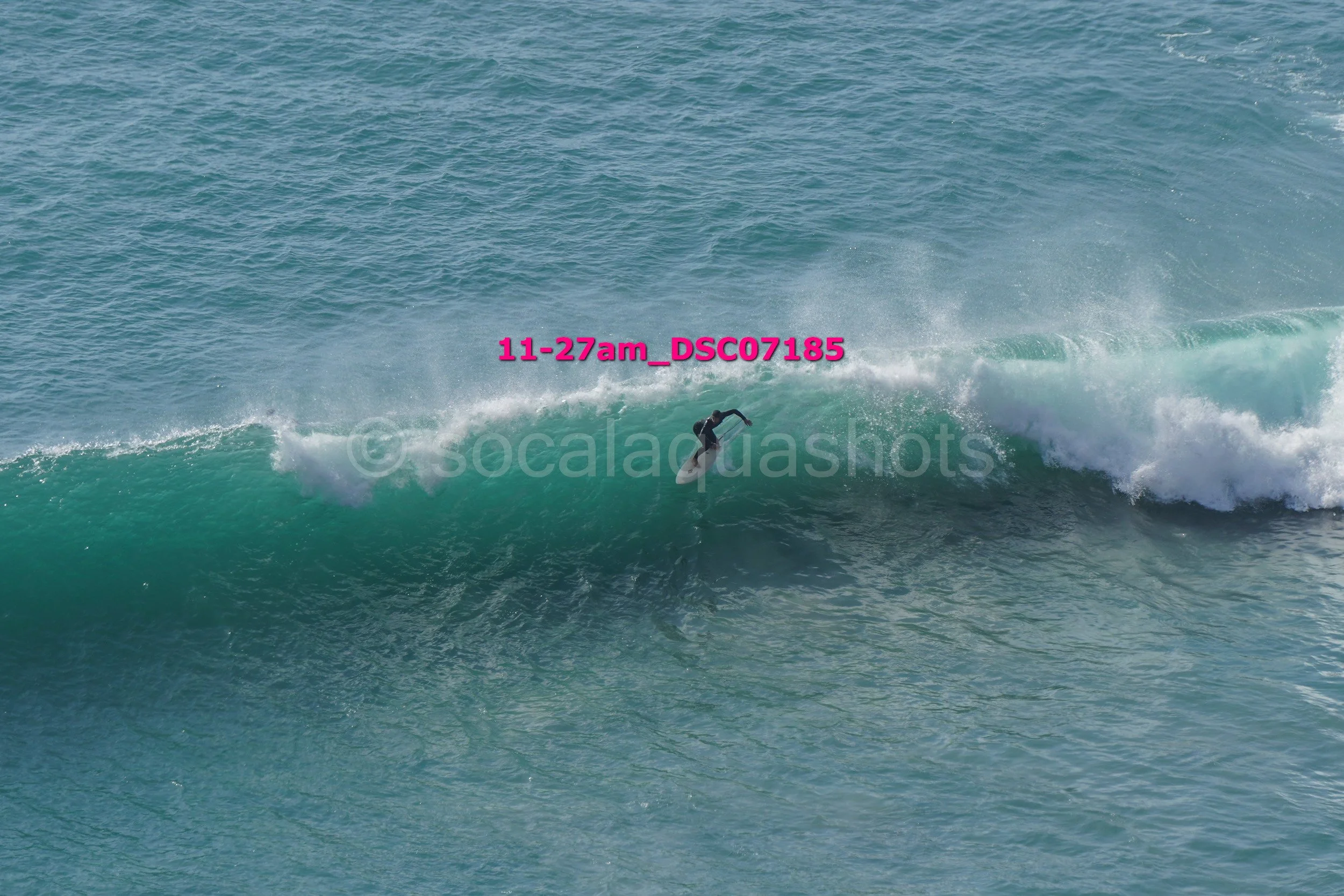 A person surfing on a large wave in the ocean.
