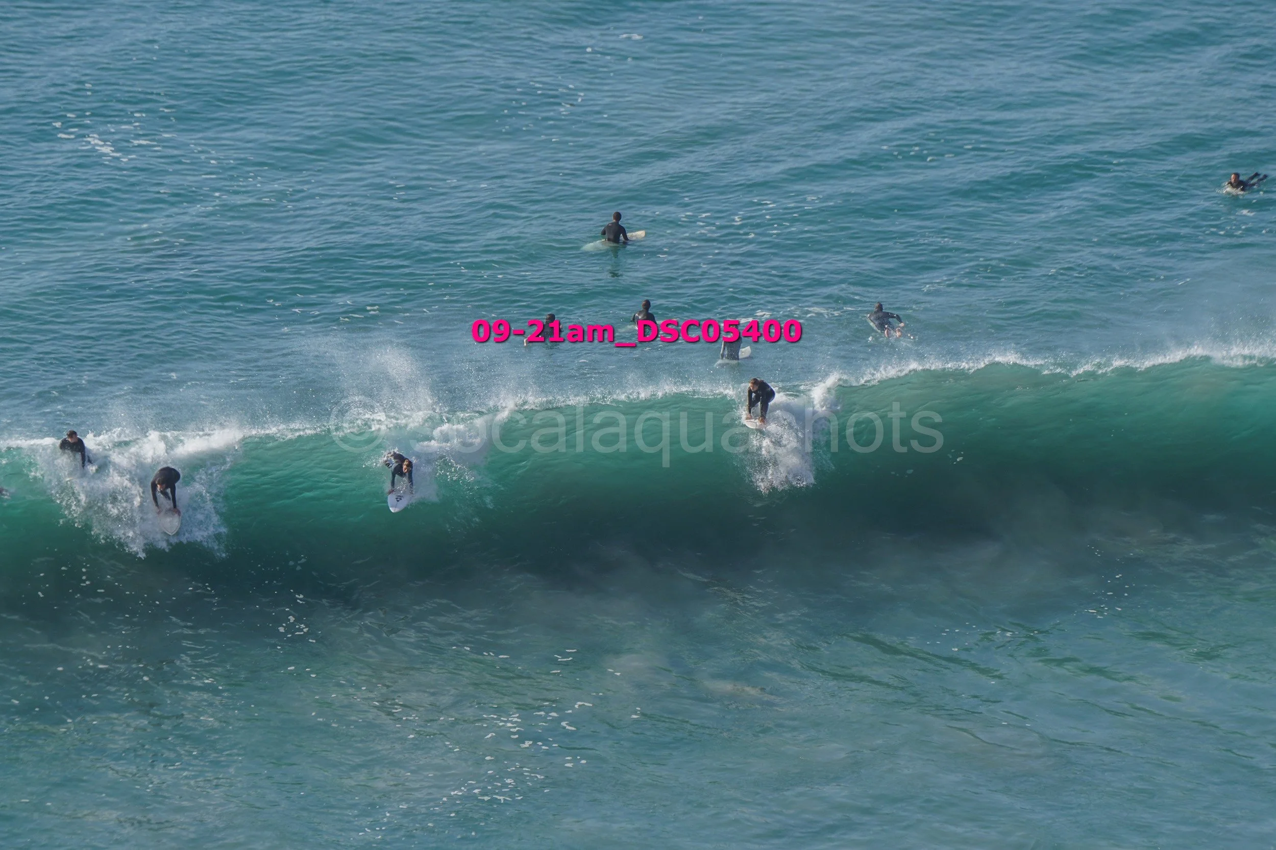 Multiple surfers riding a wave in the ocean.