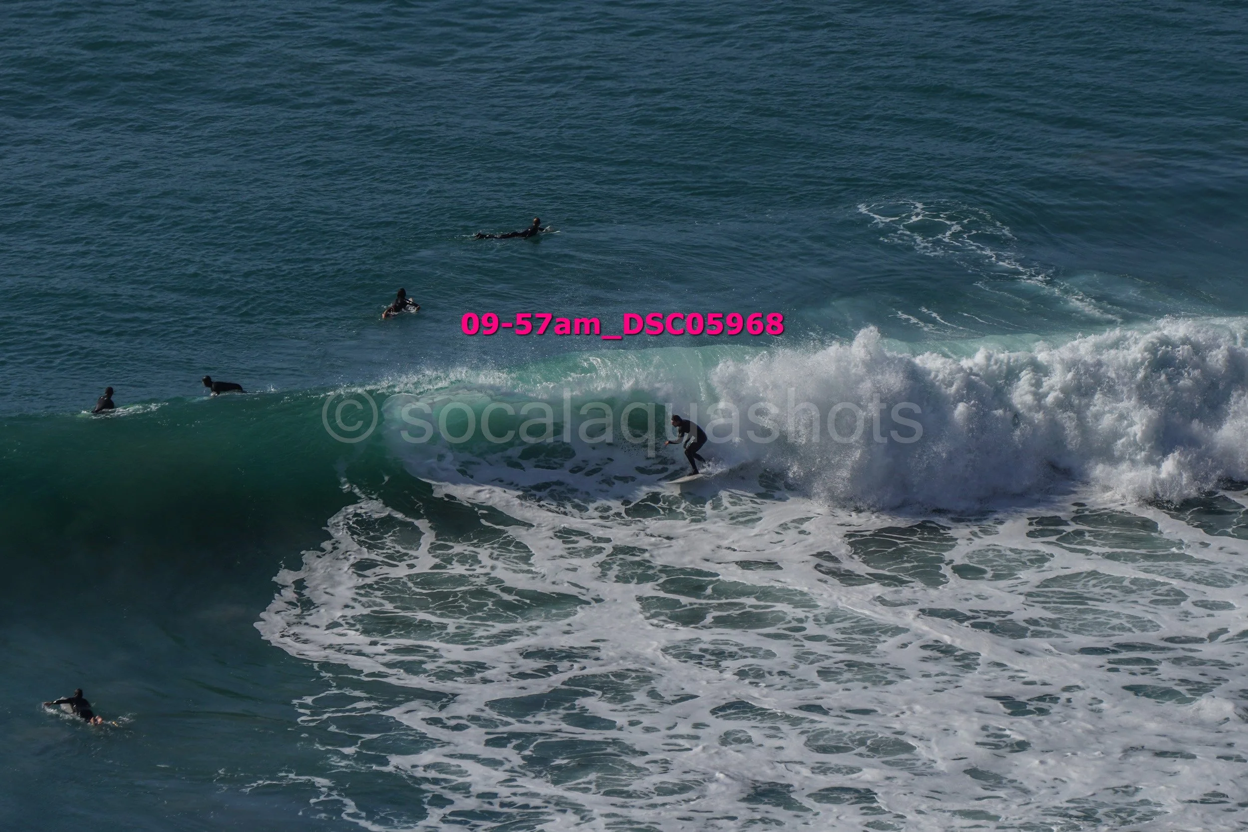 Surfers riding and waiting for waves at the beach with ocean water