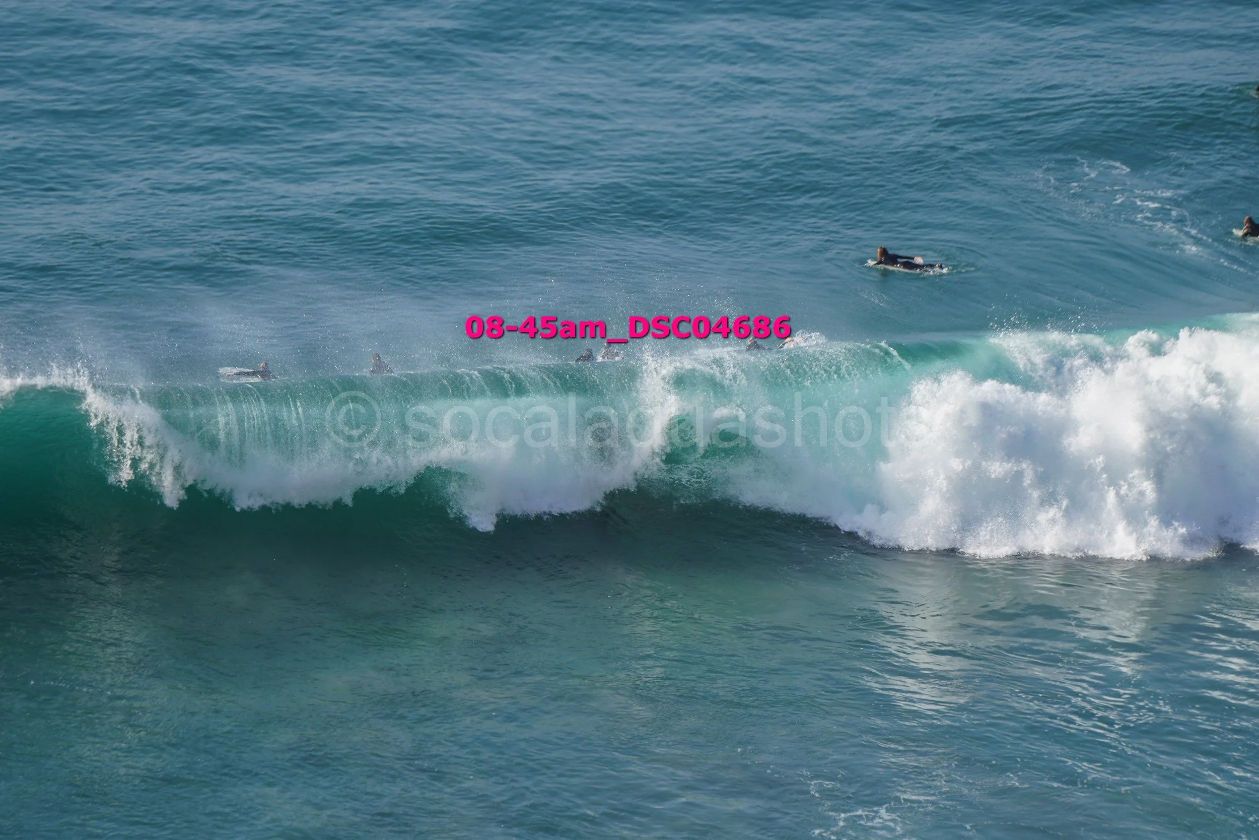 People surfing and swimming in the ocean with waves