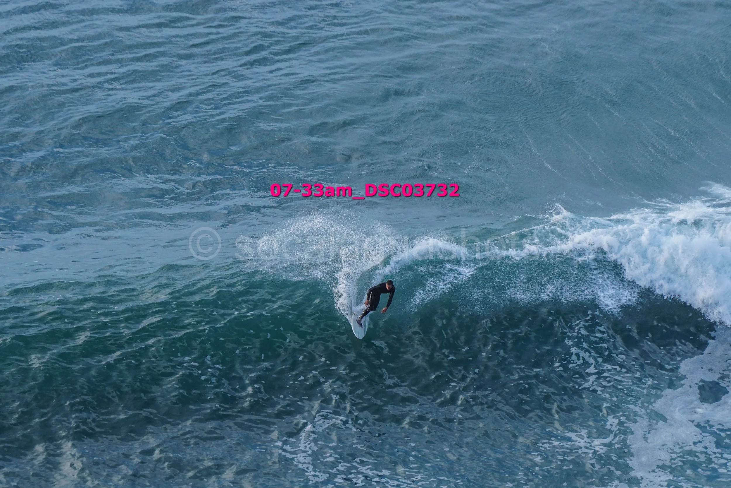 A person surfing on a large ocean wave during daylight hours.
