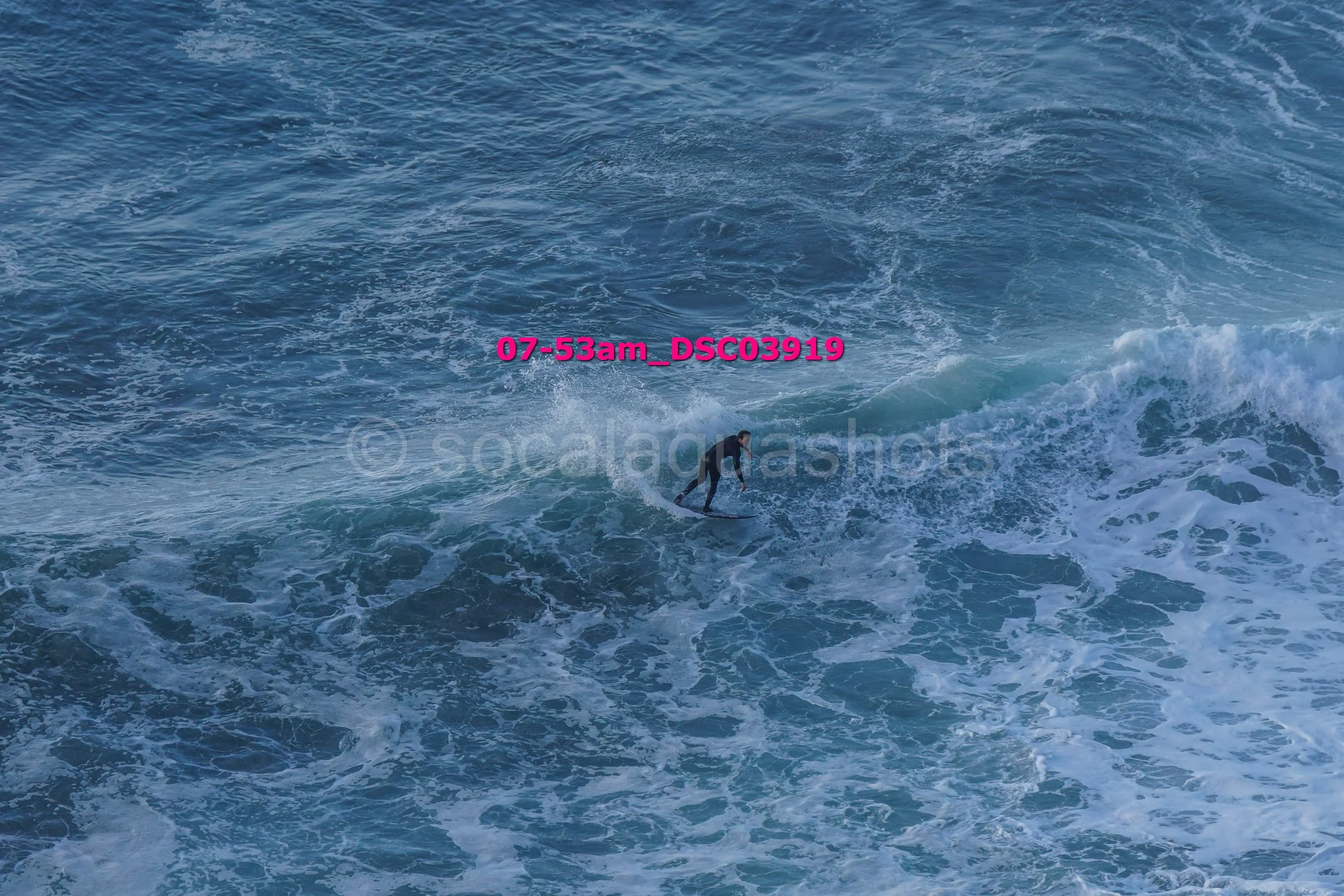 A person surfing on a wave in the ocean during daytime.