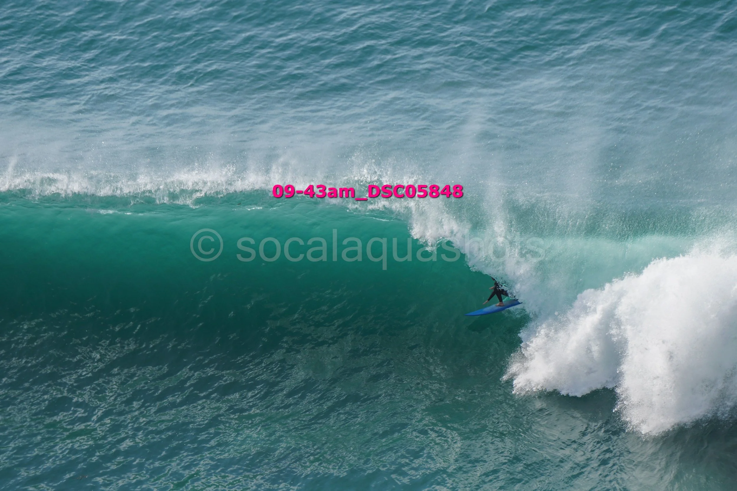 A person surfing a large wave in the ocean.