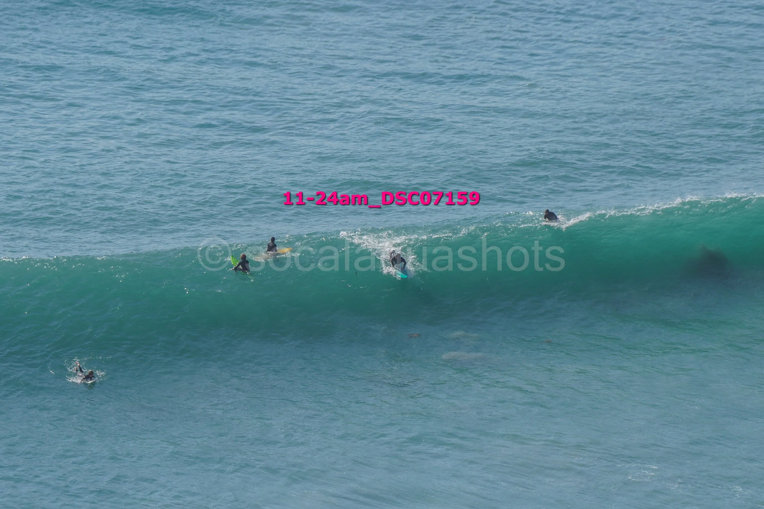 Group of surfers riding and waiting on ocean waves in the water.