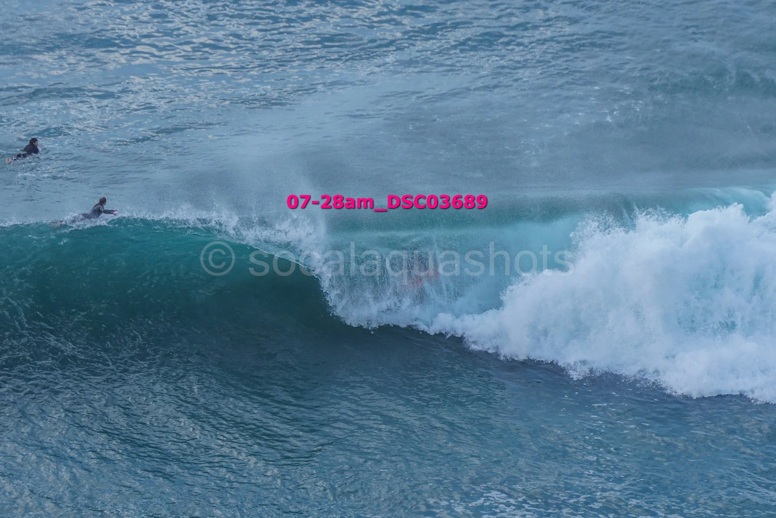 Surfers riding large ocean waves in the water.