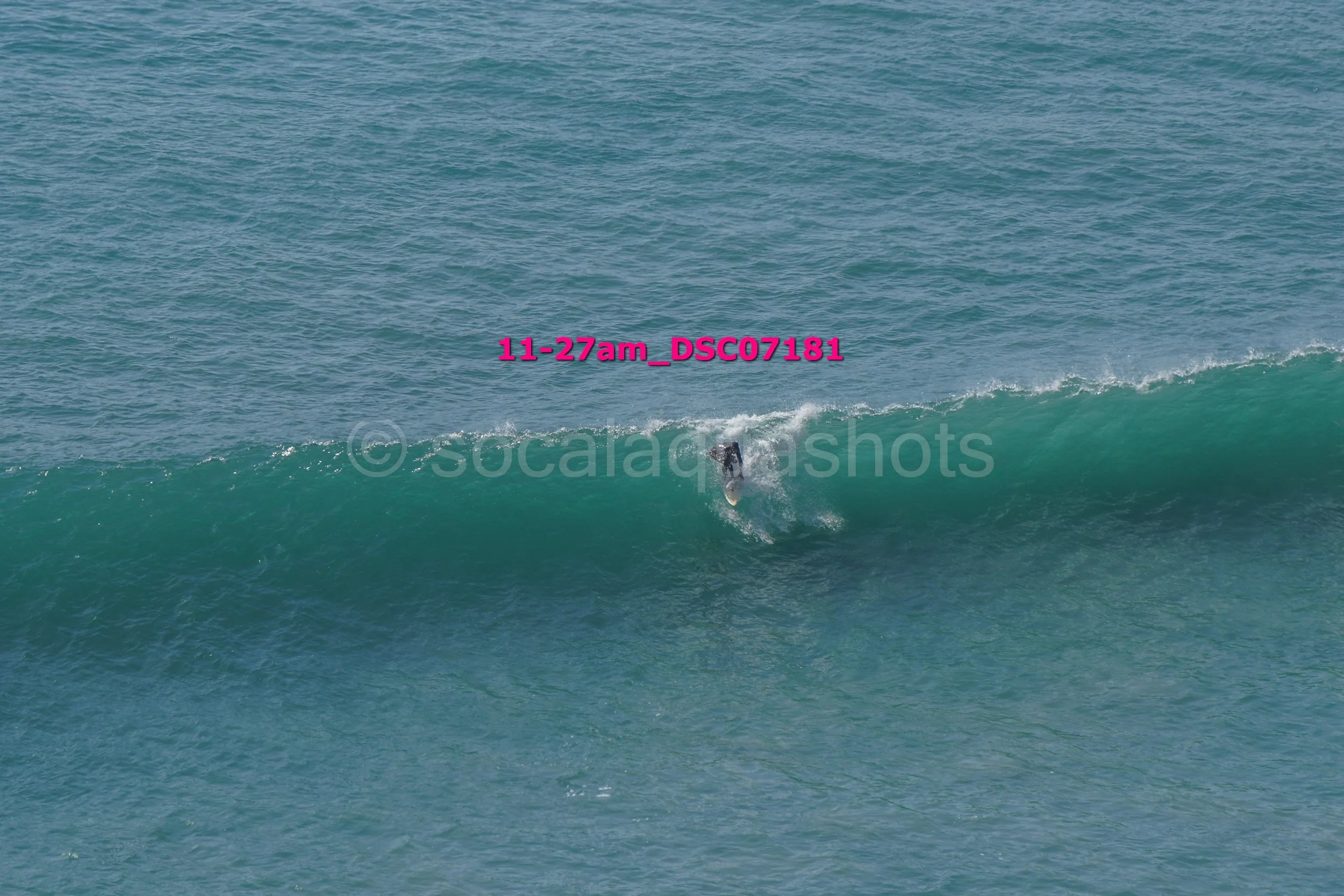 A person surfing on a wave in the ocean during daytime.