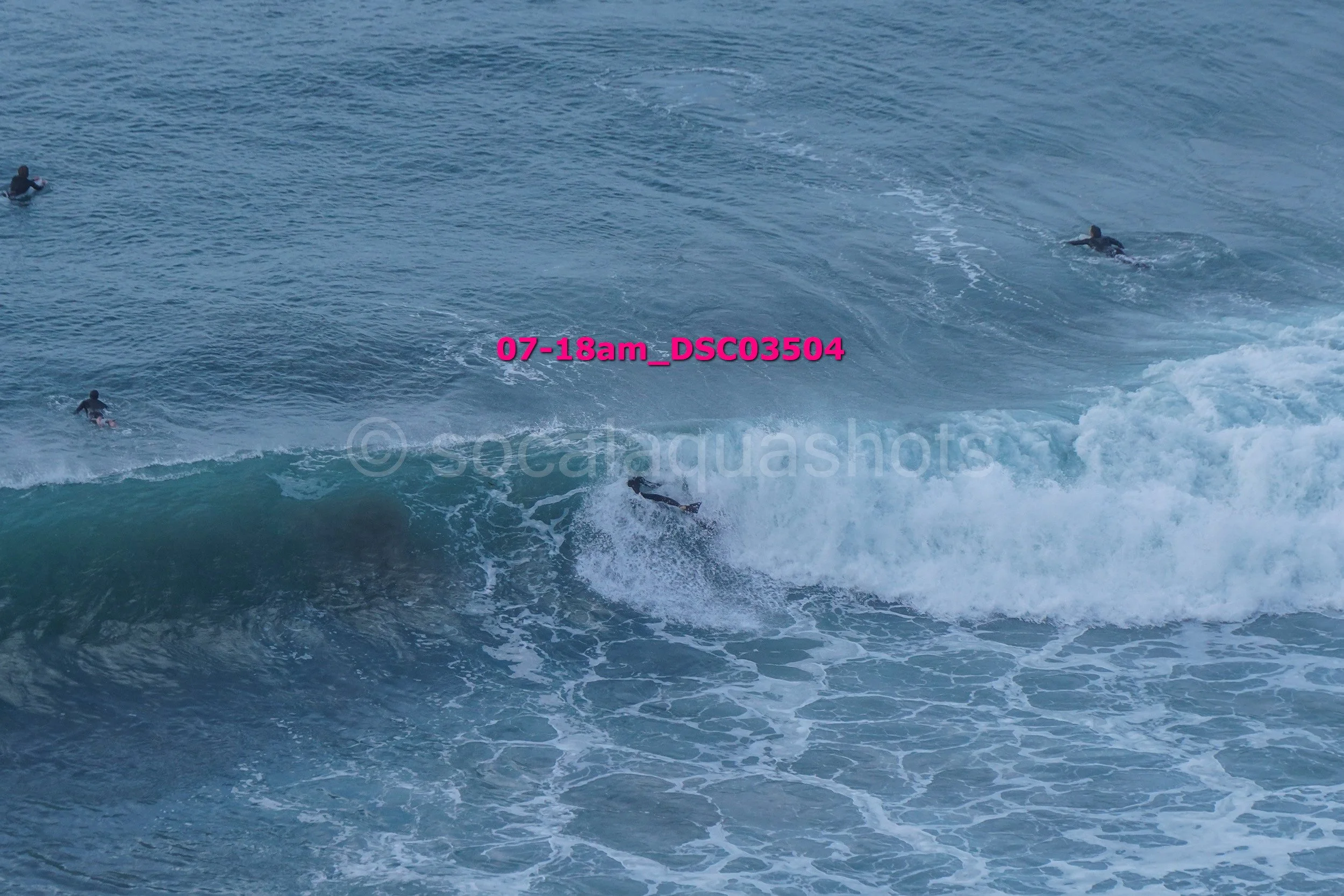 Surfers and swimmers in the ocean with large waves.