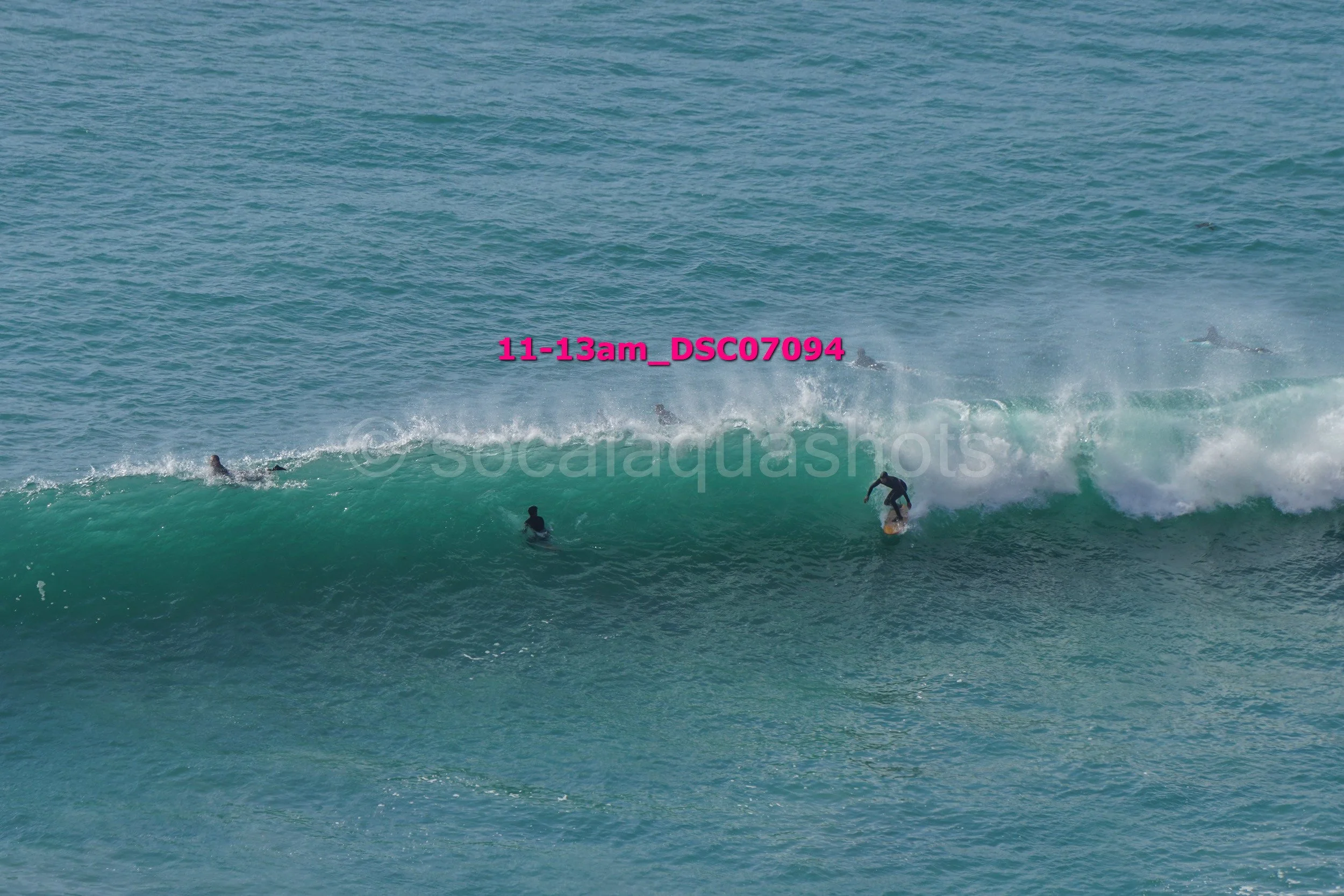 Surfer riding a wave with several surfers in the water nearby