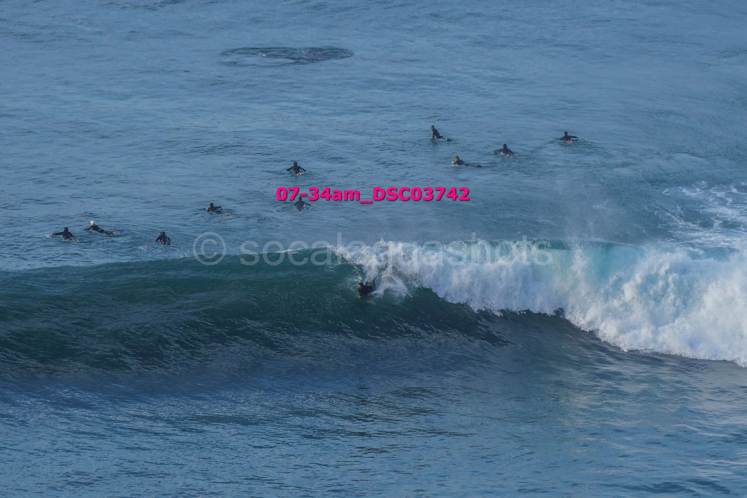 Surfer riding a wave with multiple surfers in the water nearby