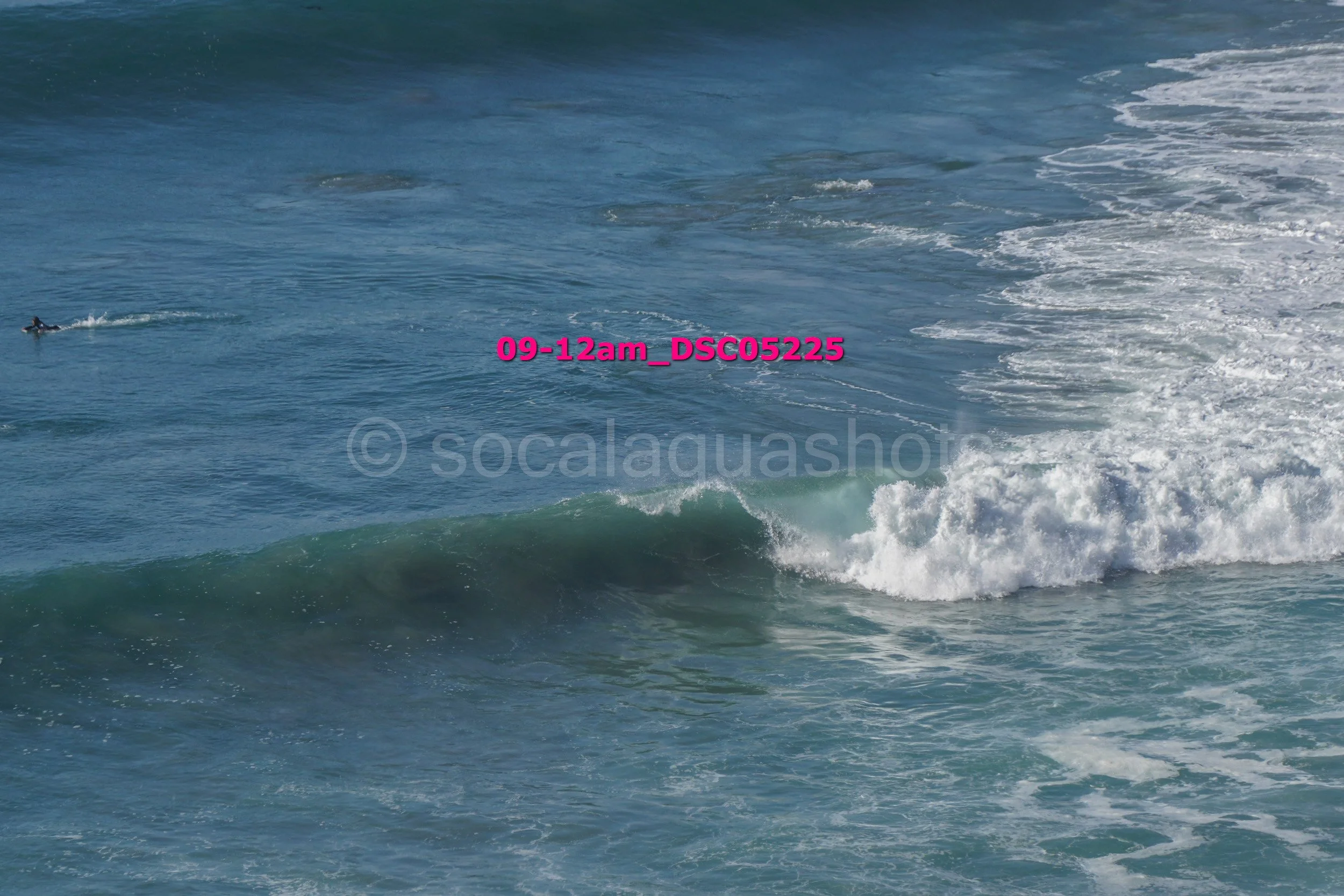 A small surfer riding a wave in the ocean.