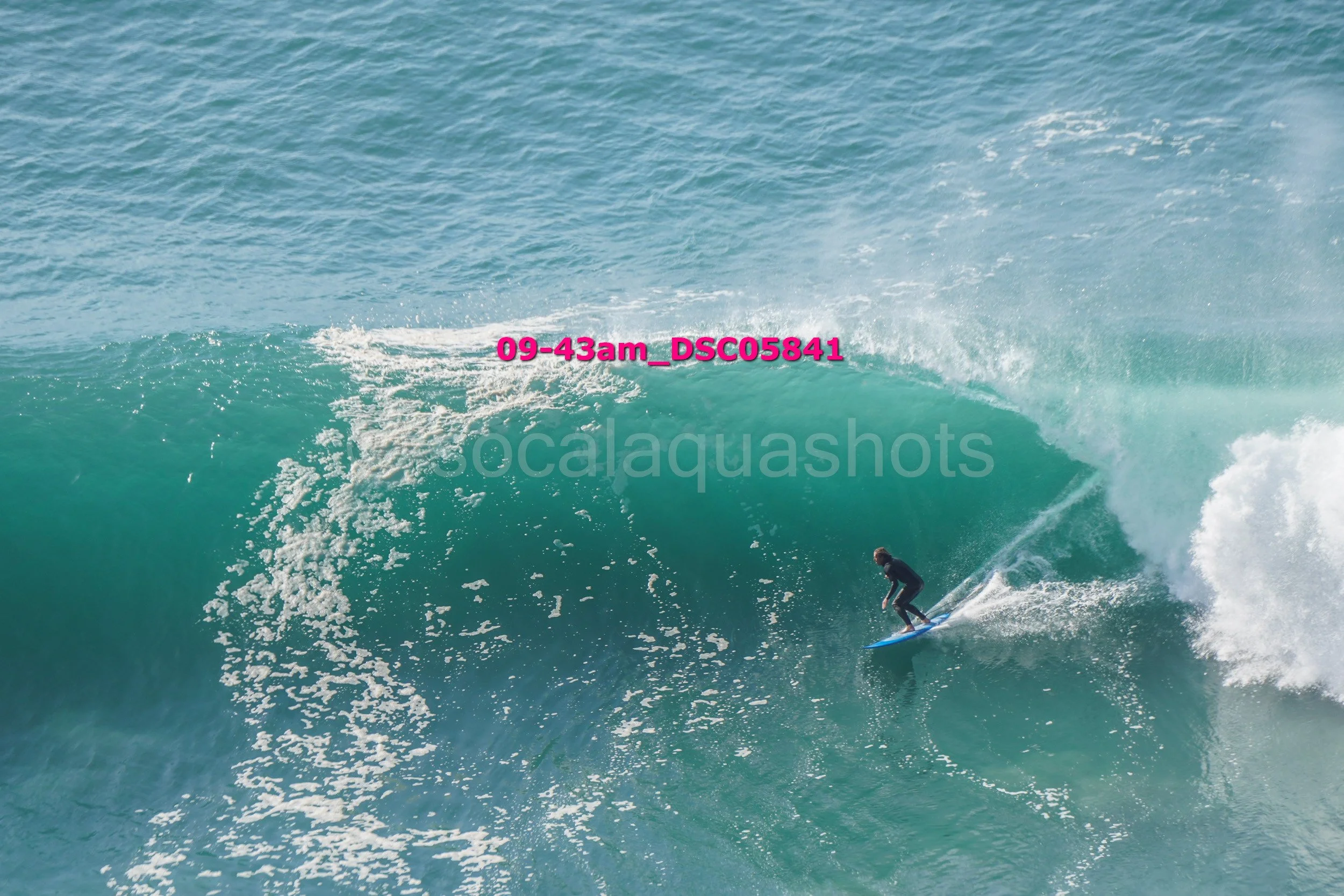A person surfing on a large wave in the ocean.