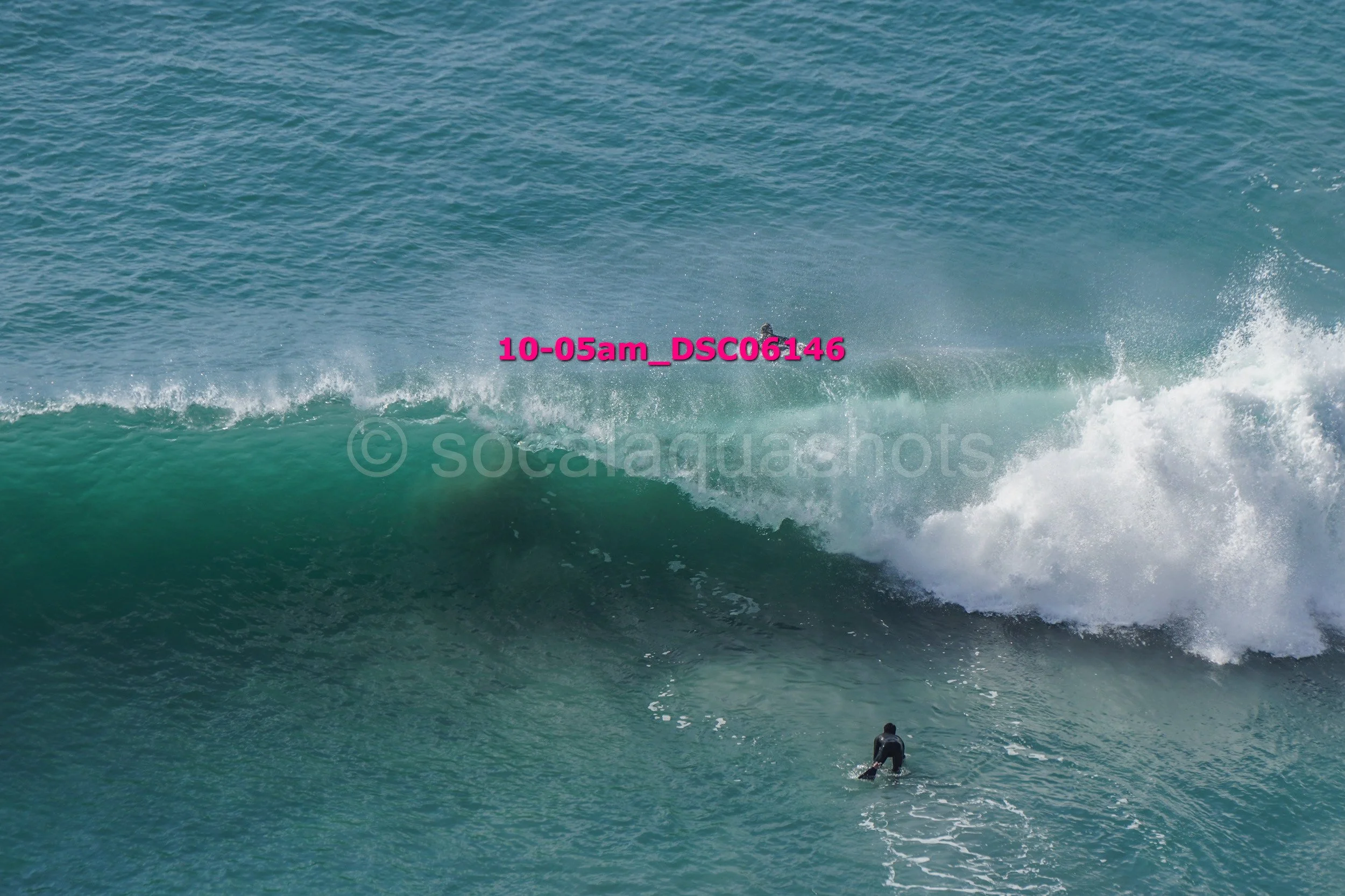 A person surfing on a large wave in the ocean.