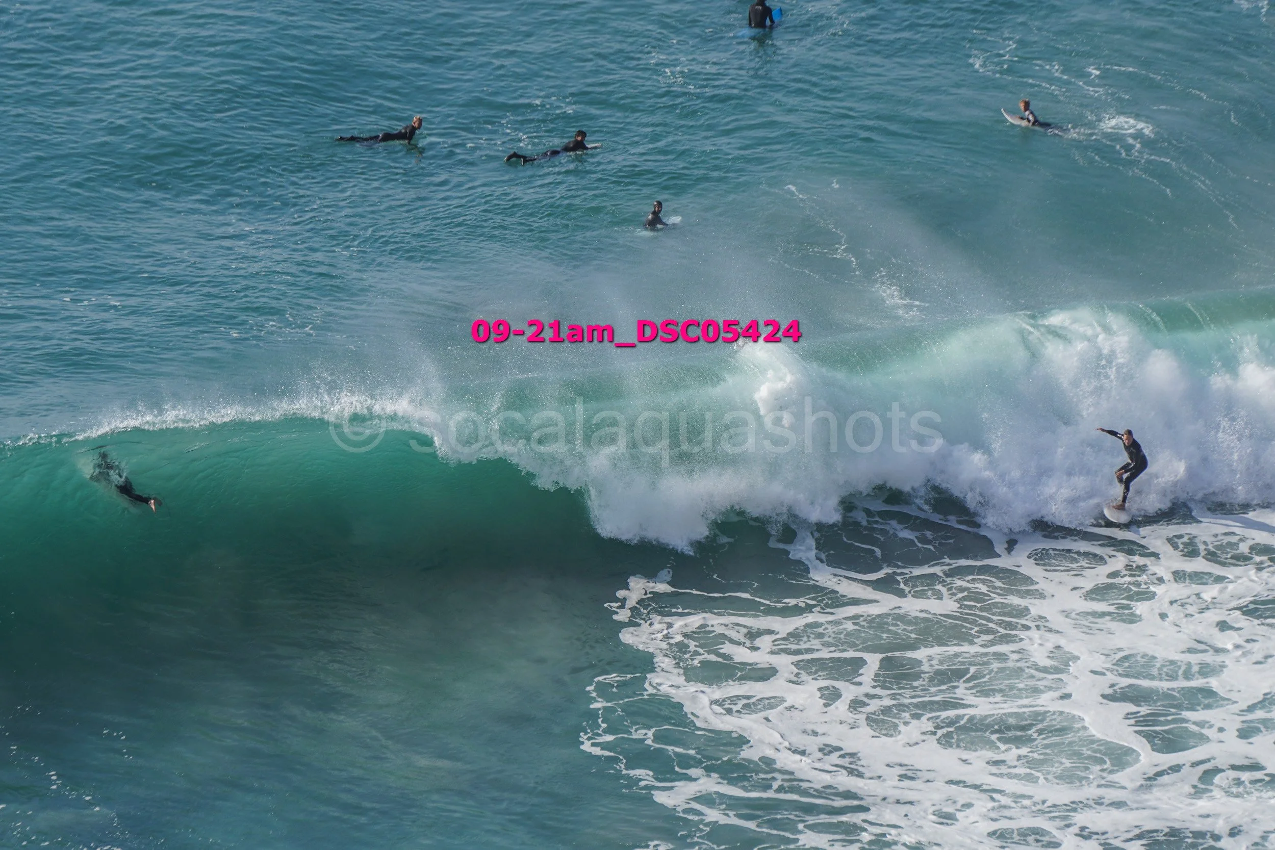 Surfers riding and paddling in the ocean waves.