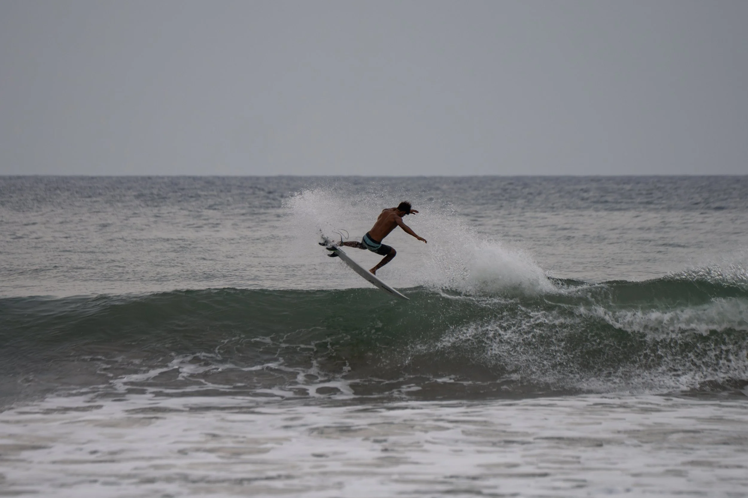 A man surfing on a wave in the ocean during daytime.