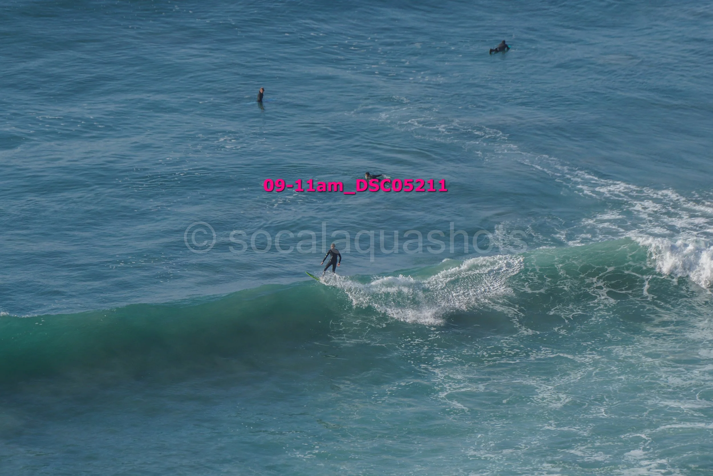 A person surfing on a wave in the ocean with several other surfers in the background.