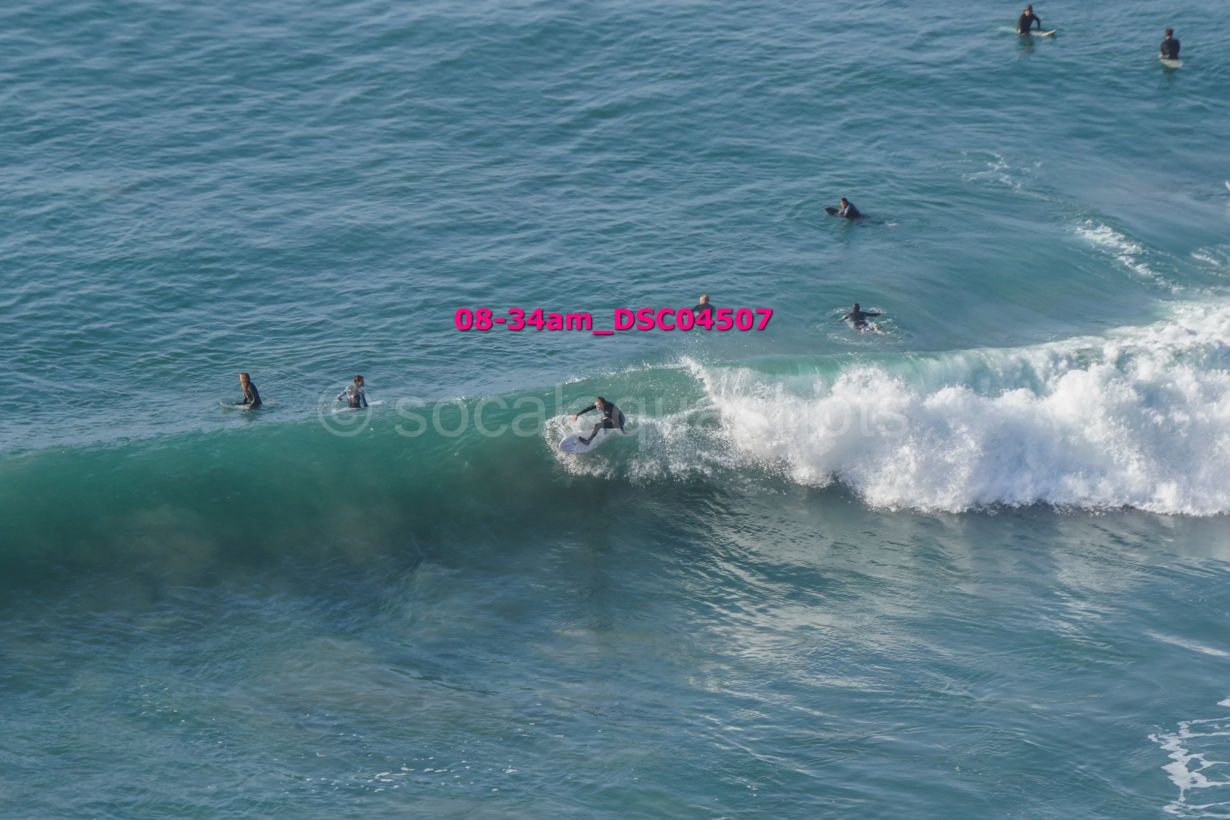 Surfer riding a wave with several surfers in the water nearby