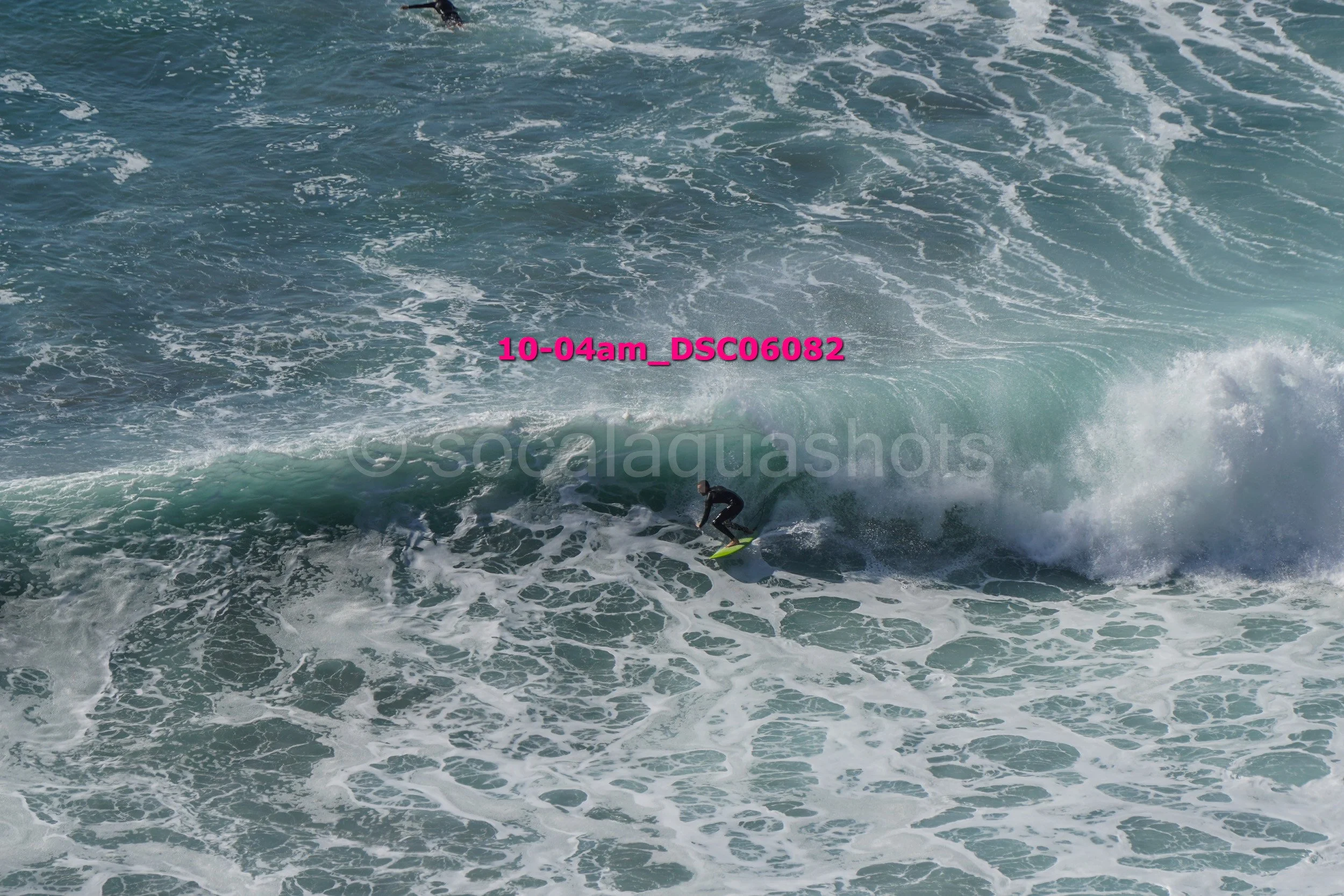 A person surfing on a large wave in the ocean.