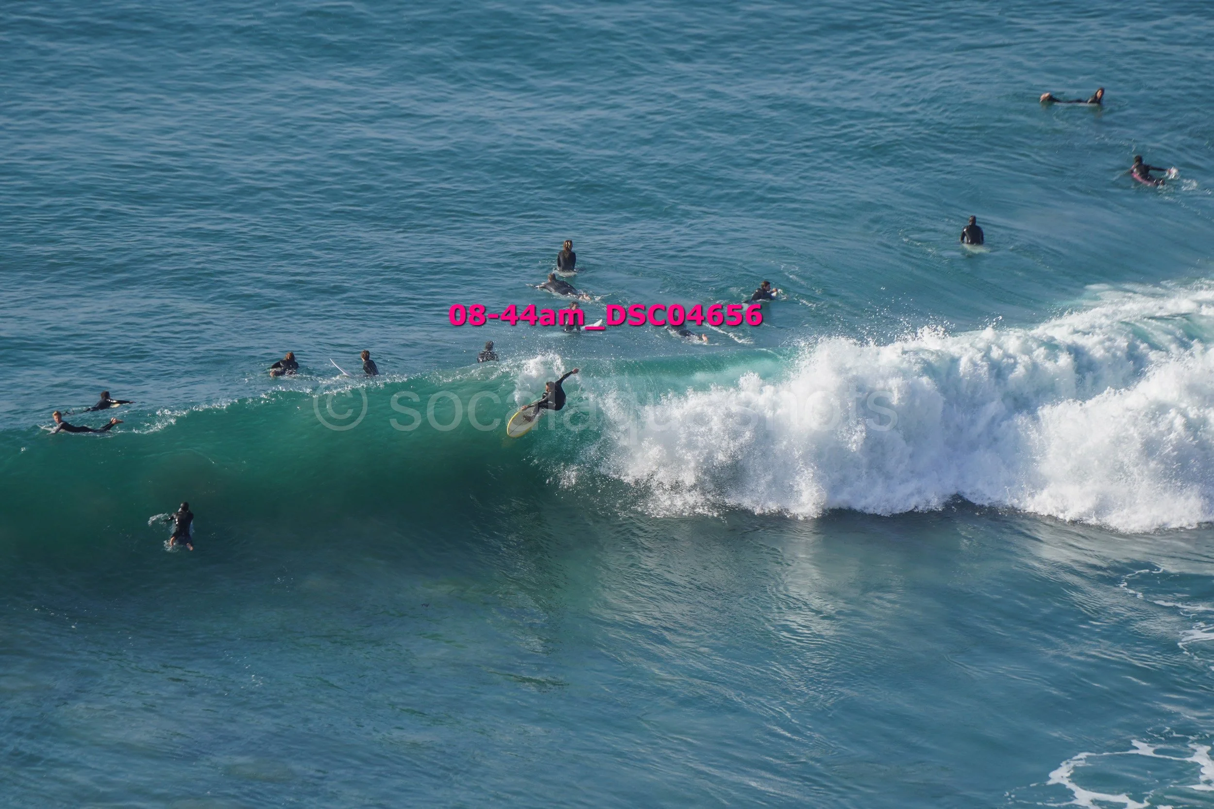 People surfing on a large wave in the ocean.