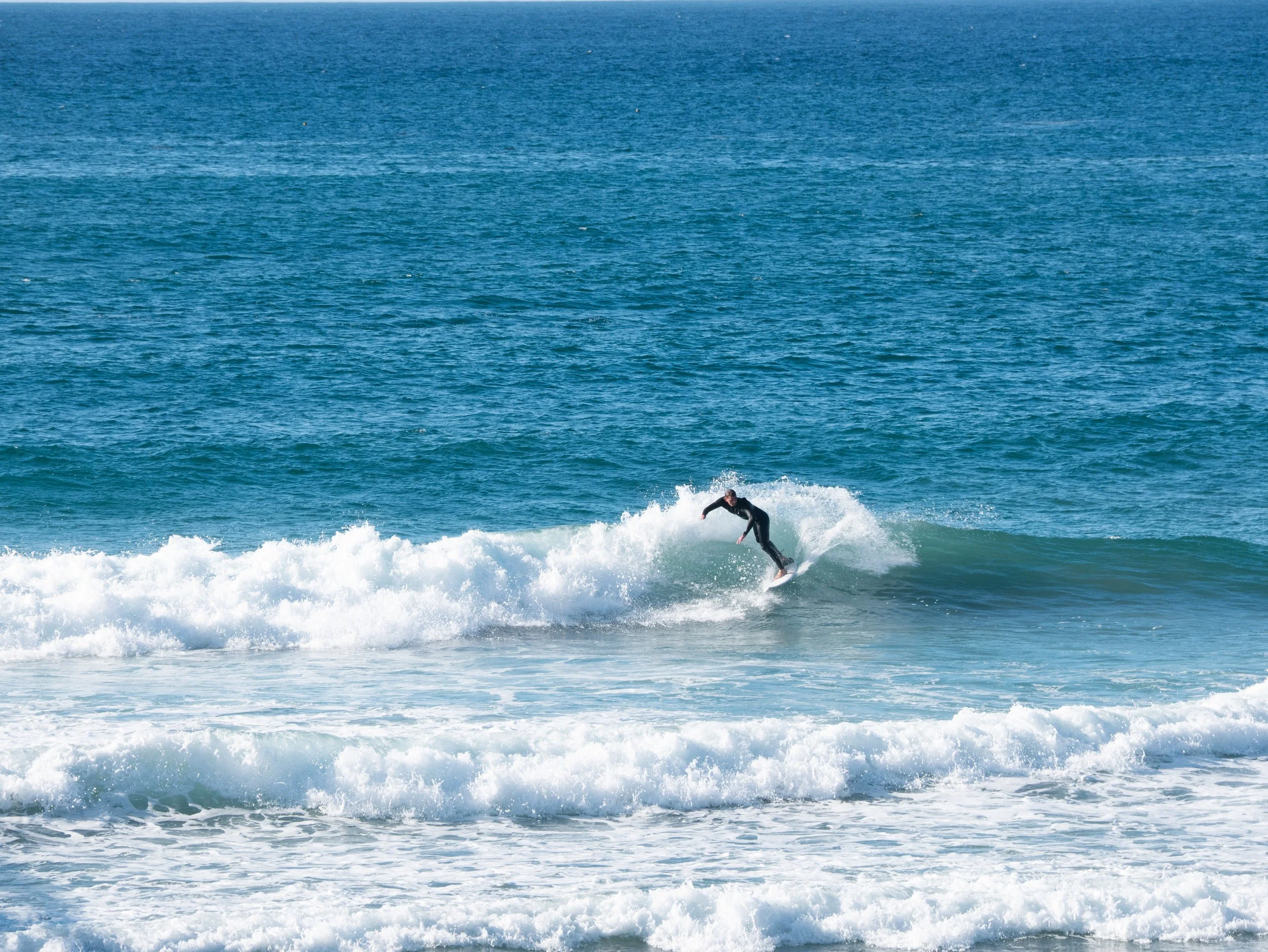 A person surfing on a wave in the ocean.
