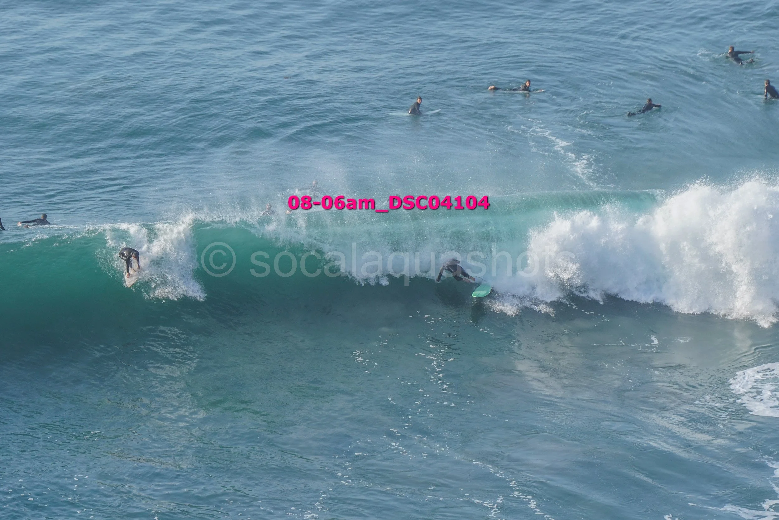 Surfer riding a wave with other surfers in the water