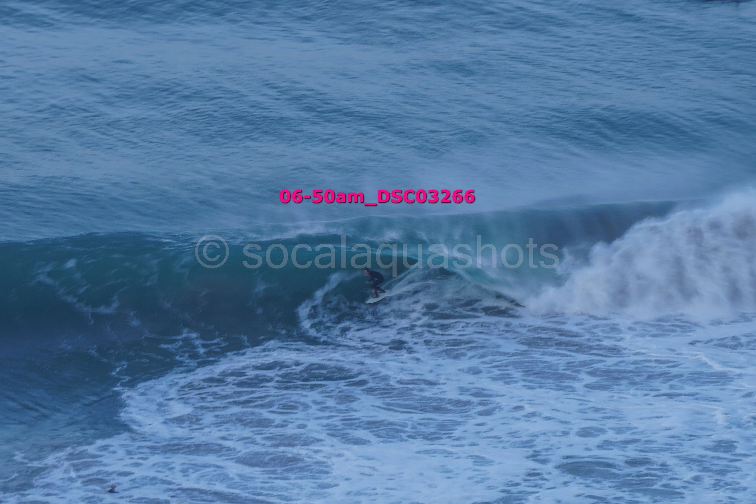 A person surfing on a large ocean wave.