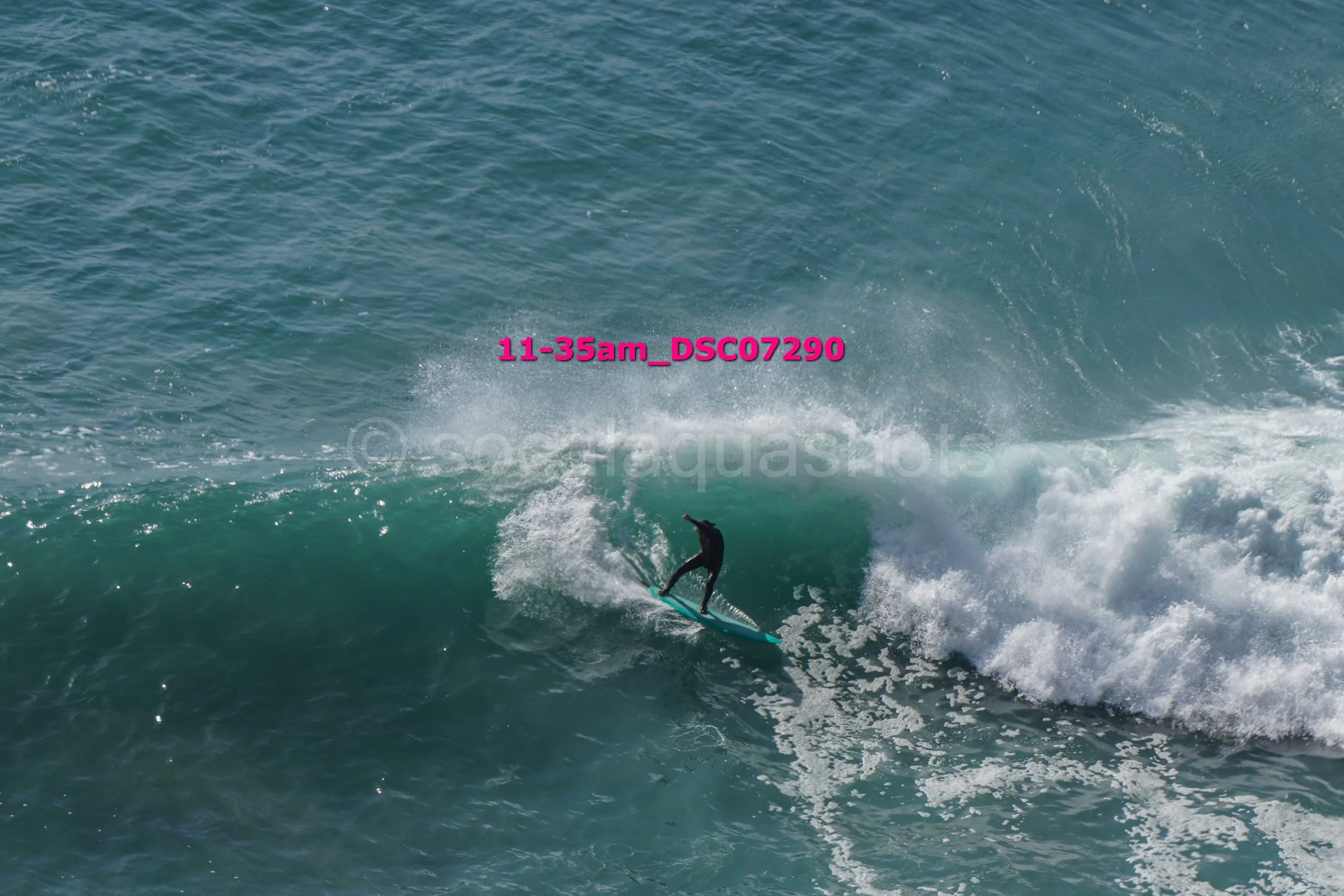 A person riding a wave on a surfboard in the ocean, with a sunset or early morning sky.