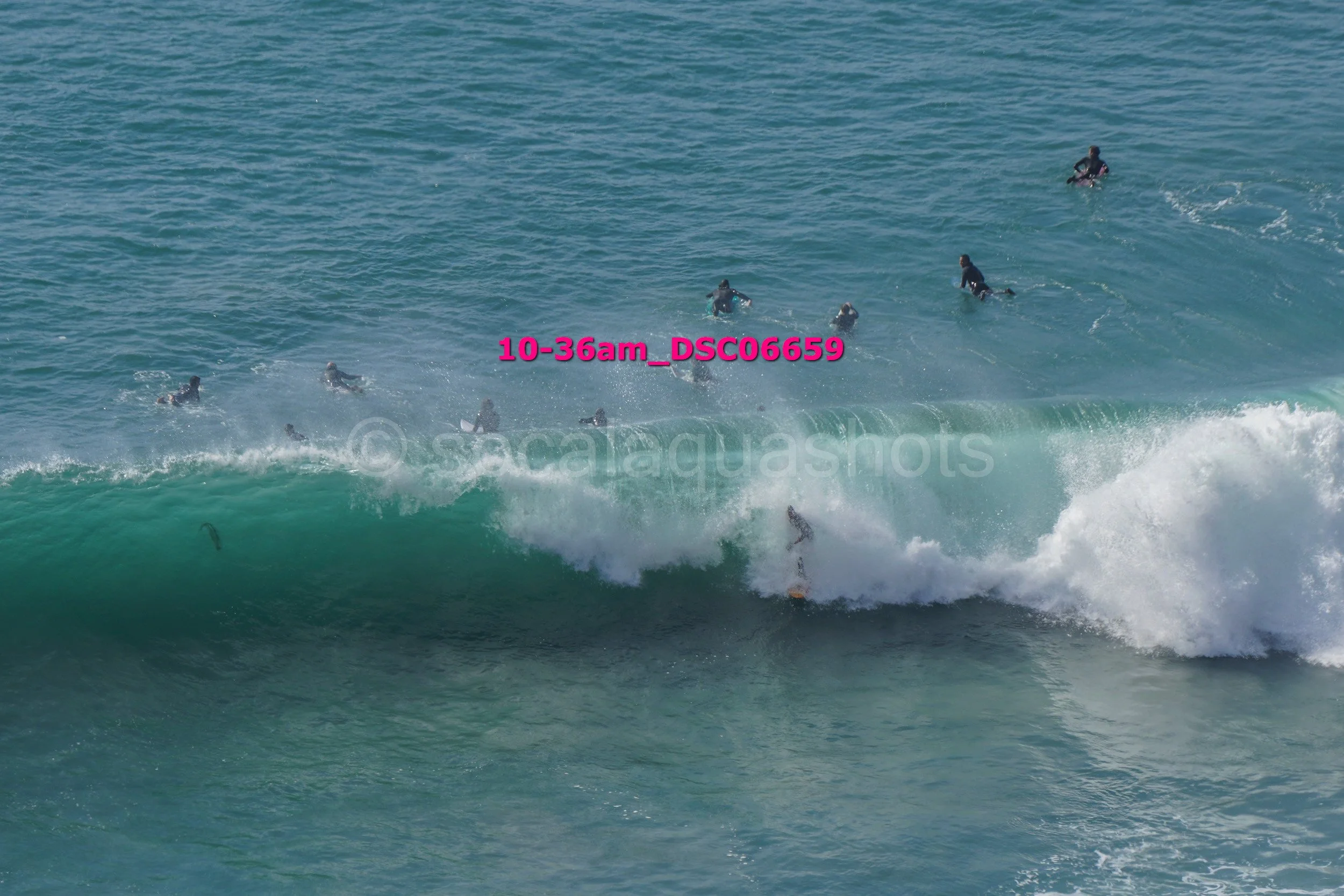 Surfers riding a large wave in the ocean.