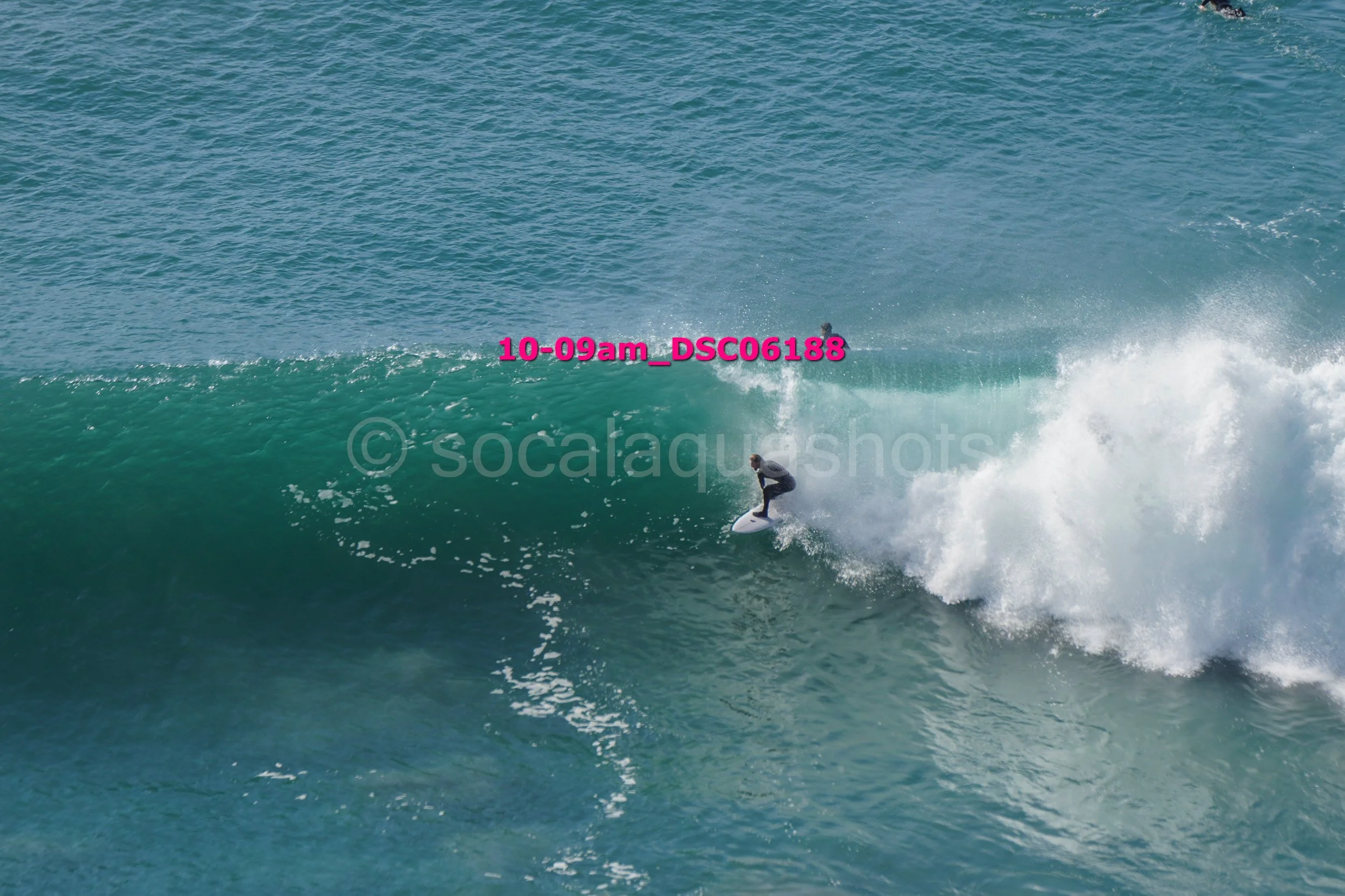 A person surfing on a large wave in the ocean.
