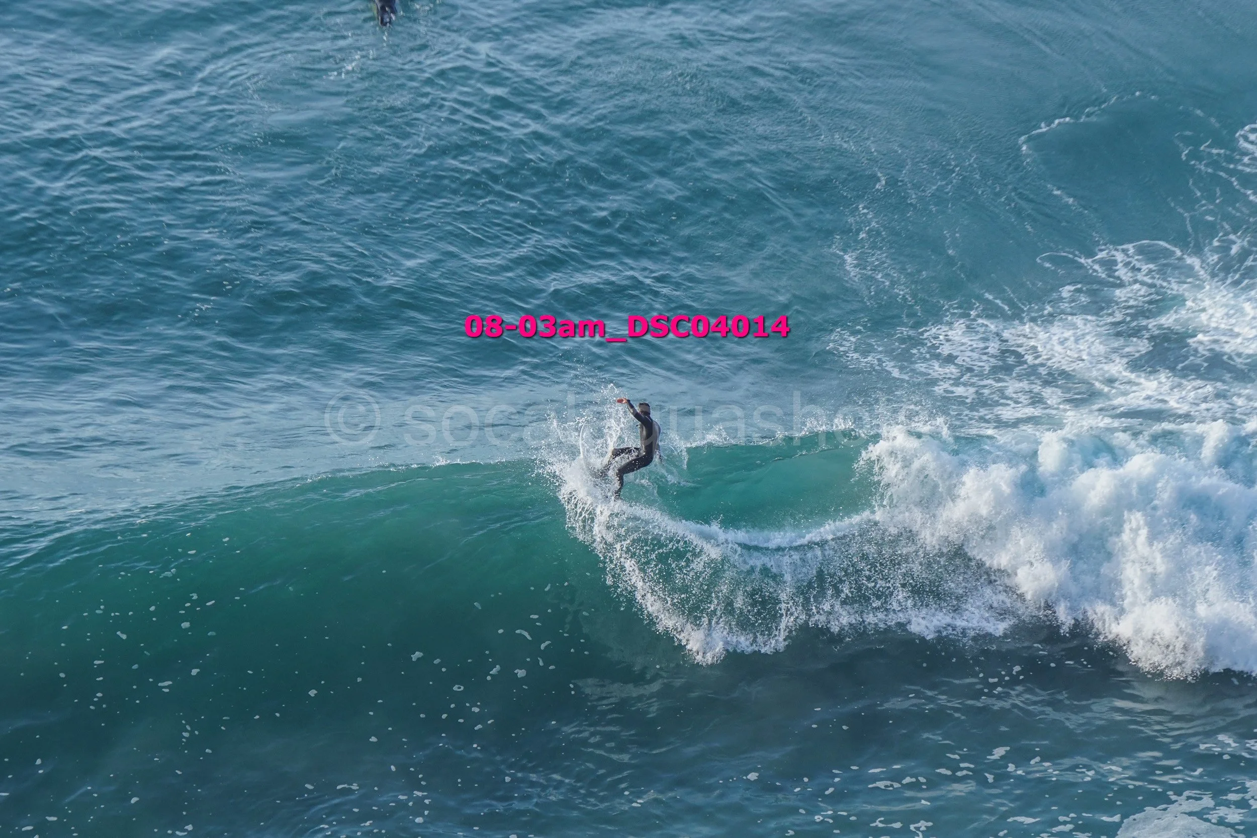 A person surfing on a wave in the ocean during daytime.