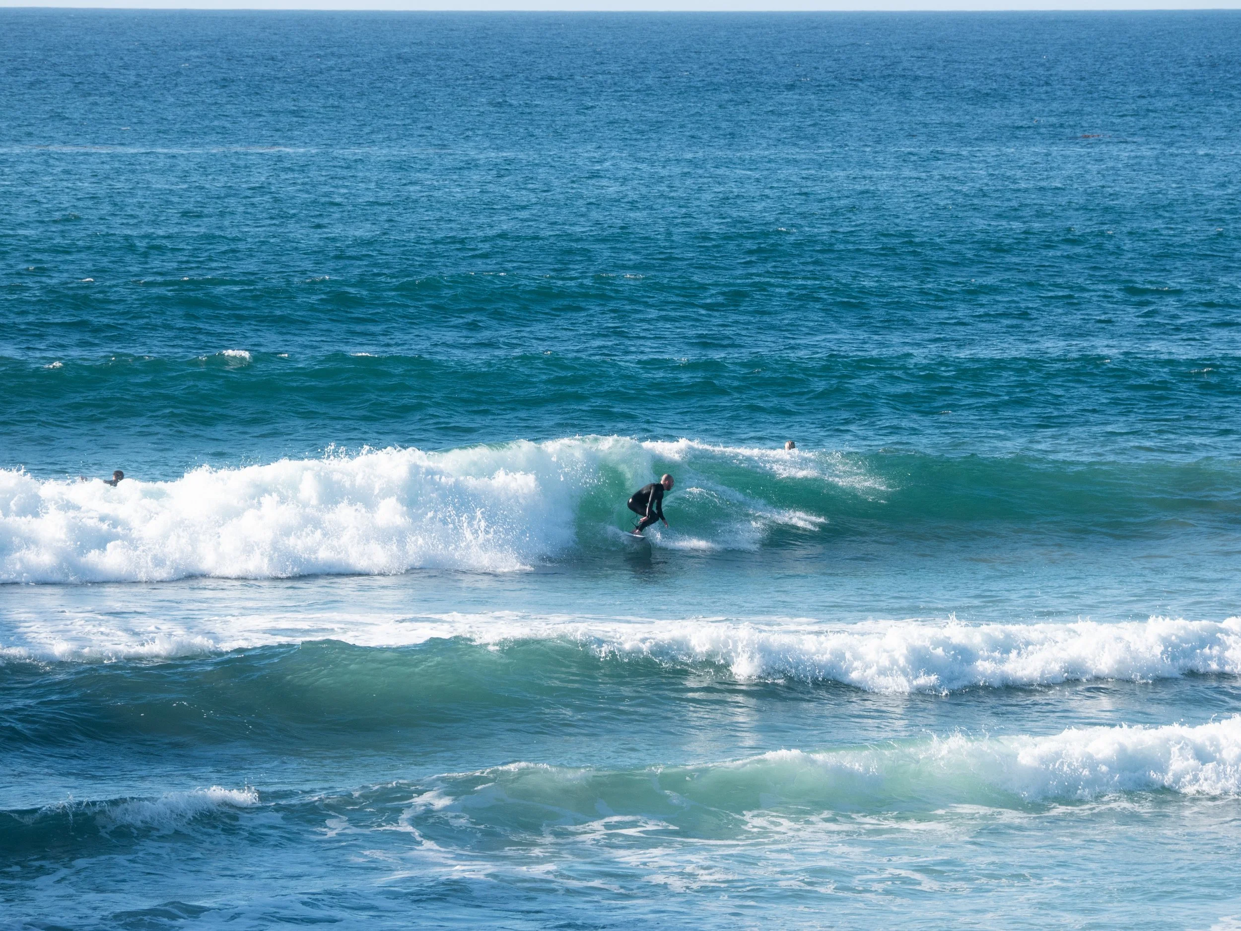A person in a wetsuit surfing a wave in the ocean.