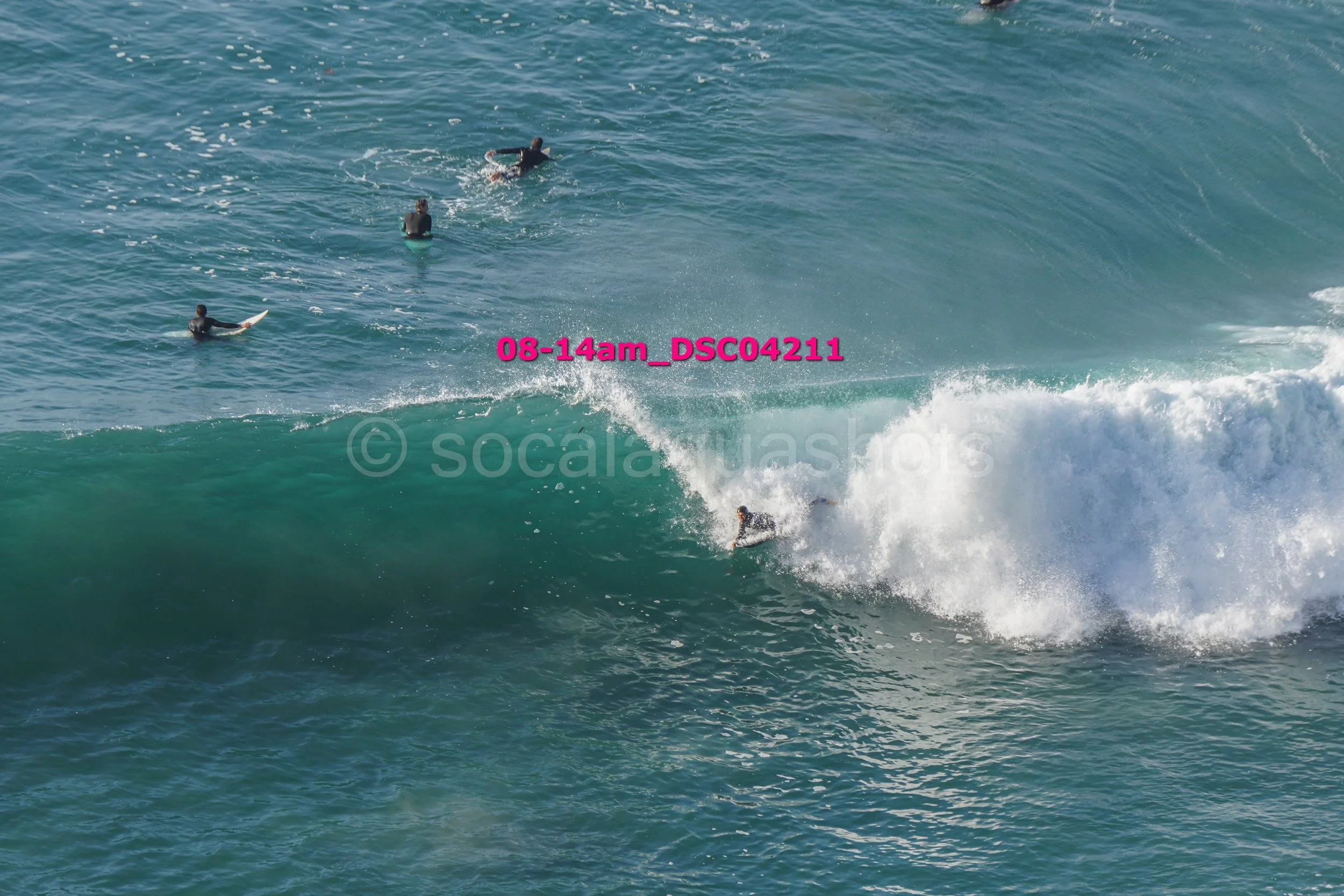 Surfers riding and waiting for waves in the ocean