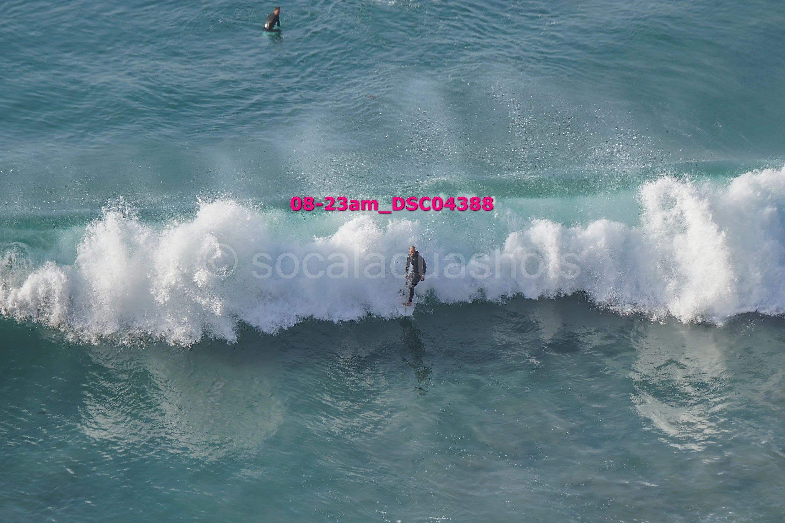 A person surfing on a wave in the ocean with water splashing around.
