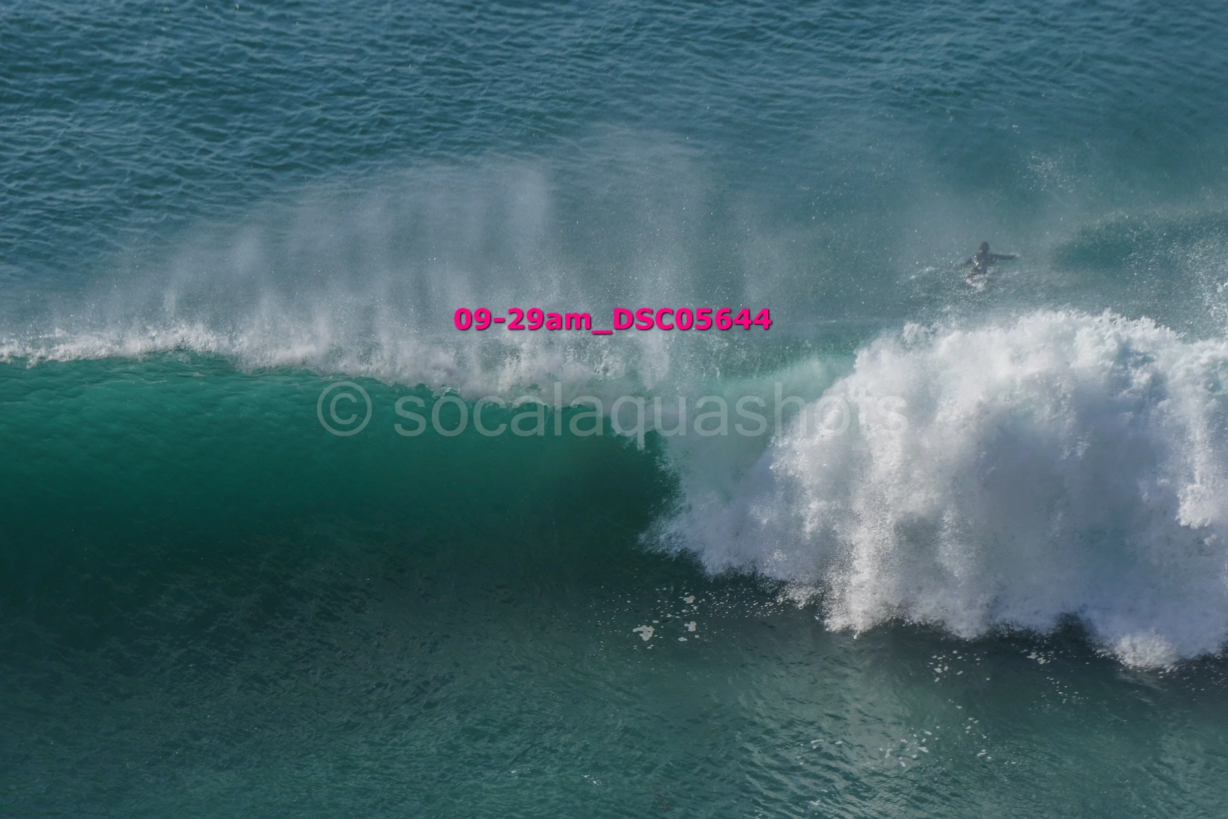 A person surfing on a large wave in the ocean.