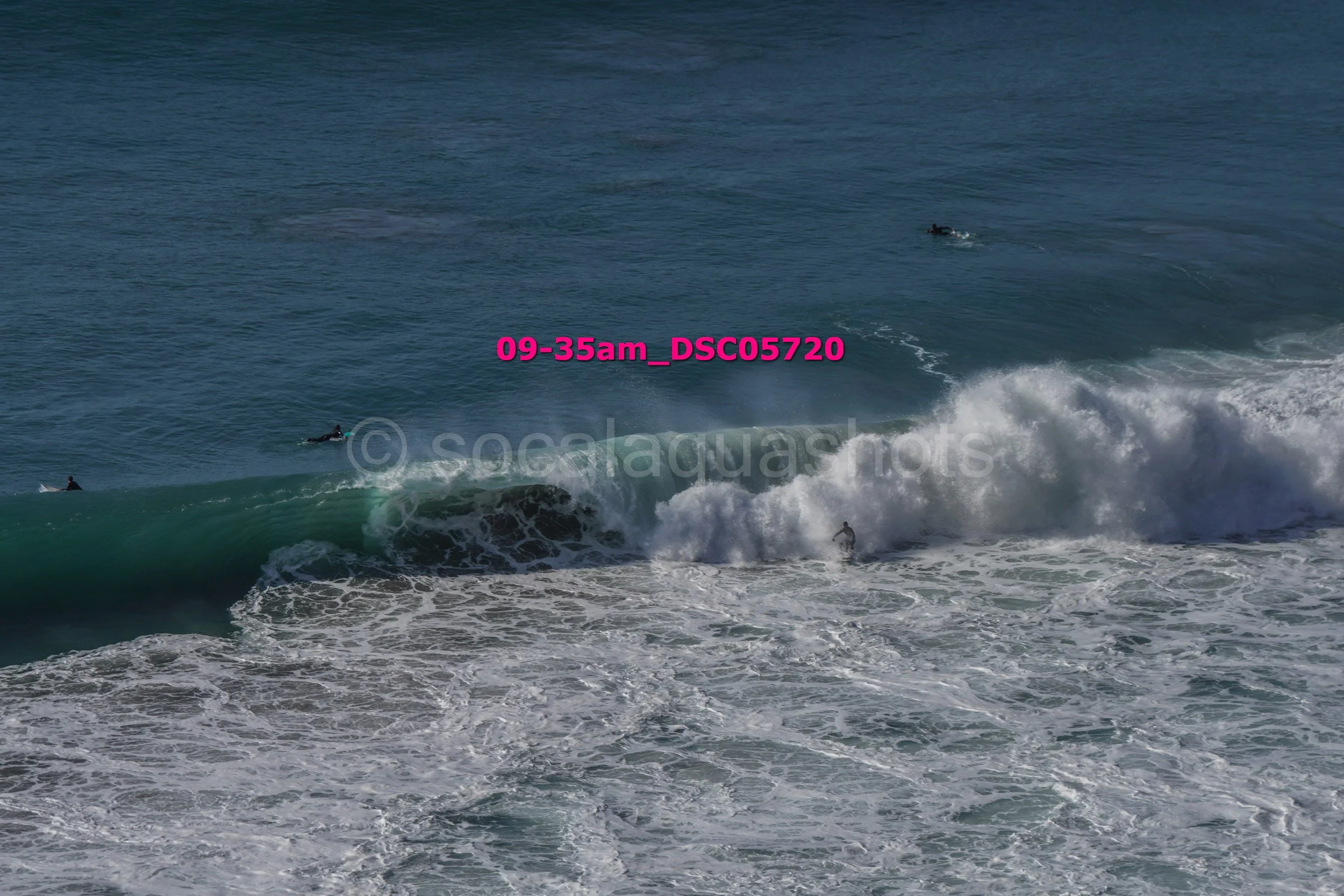Ocean waves with surfers in the water