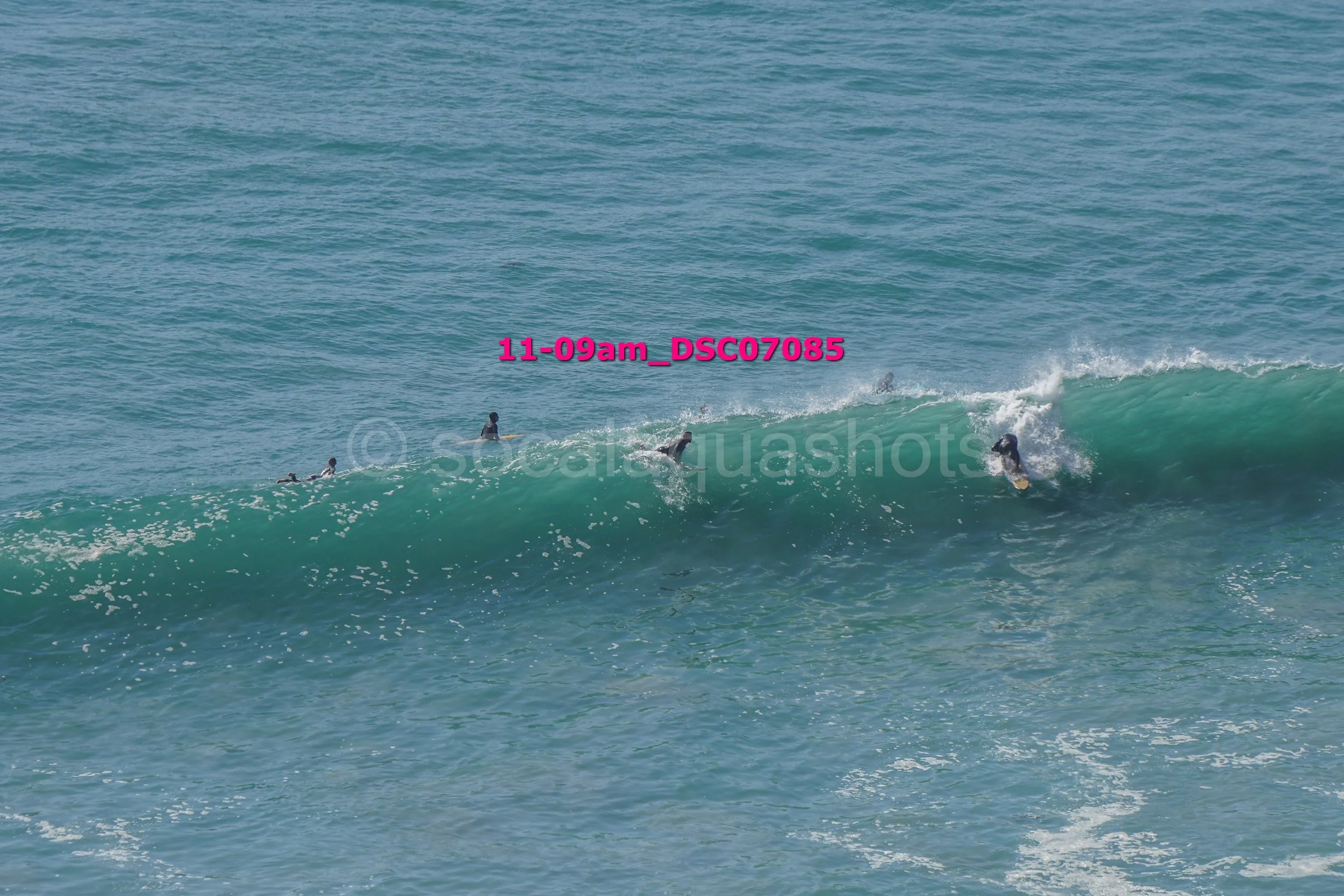 Surfers riding a wave at the beach.