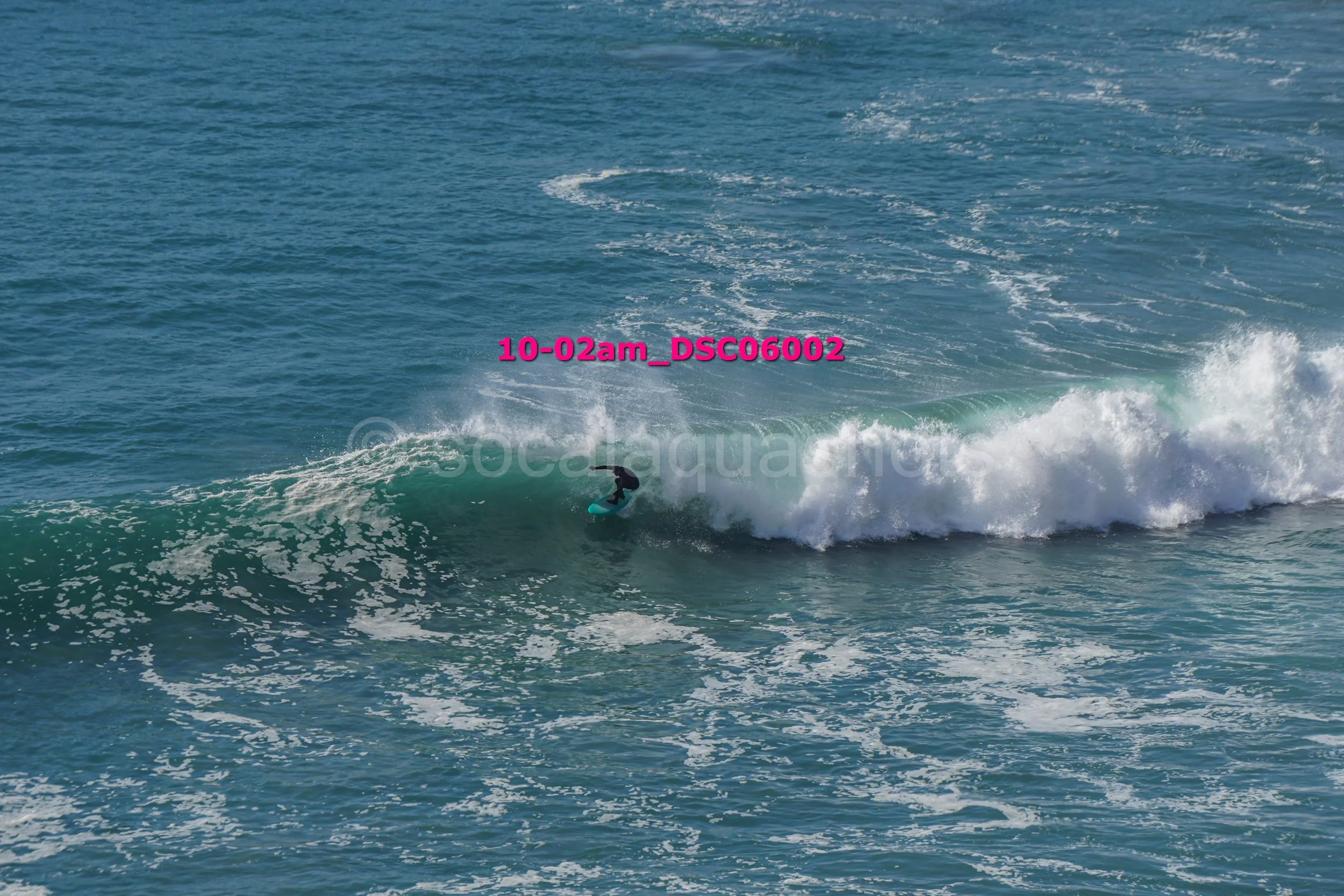 A person surfing on a wave in the ocean during daytime.