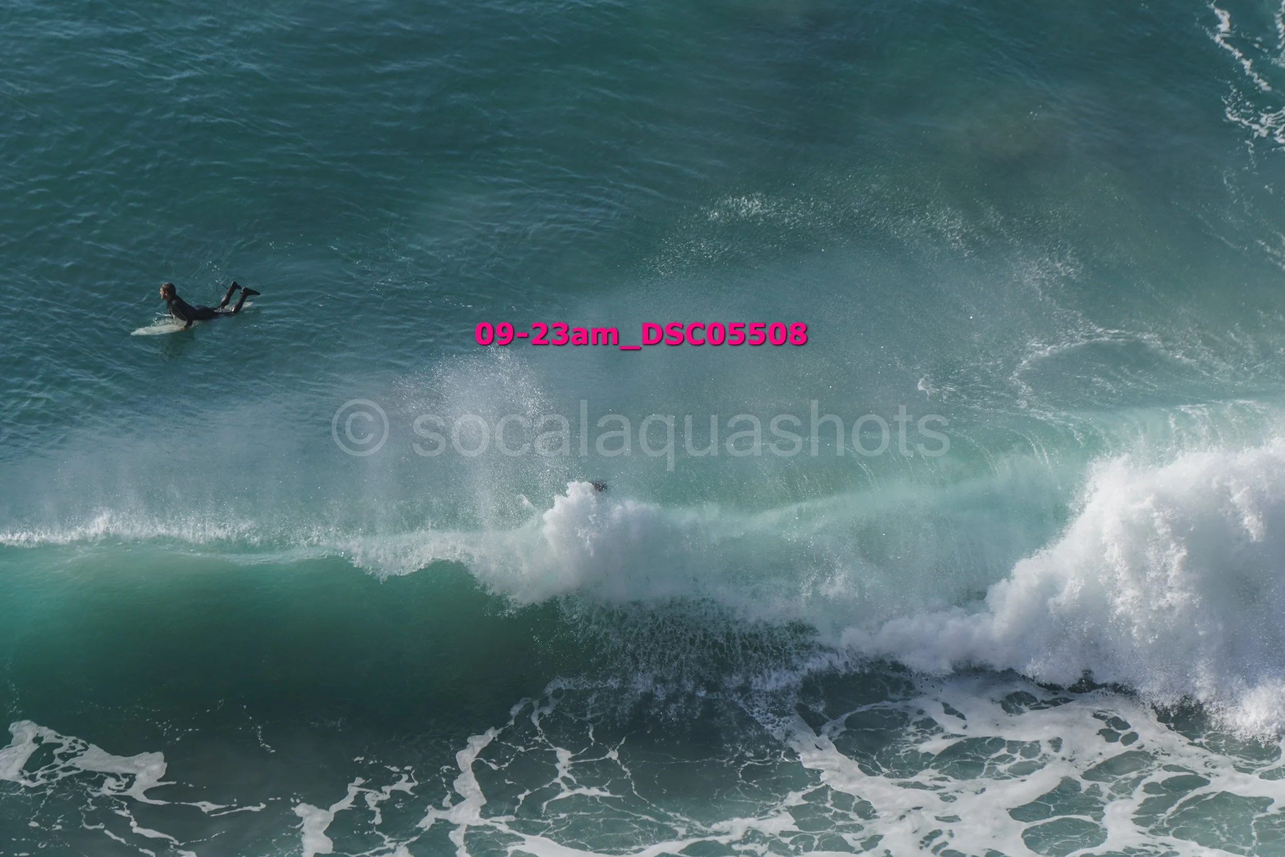 Surfer riding a large ocean wave in open water.