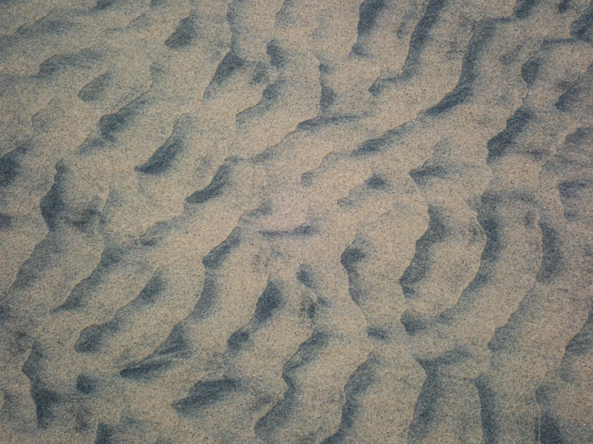 Close-up of sand with various small ripples and patterns.