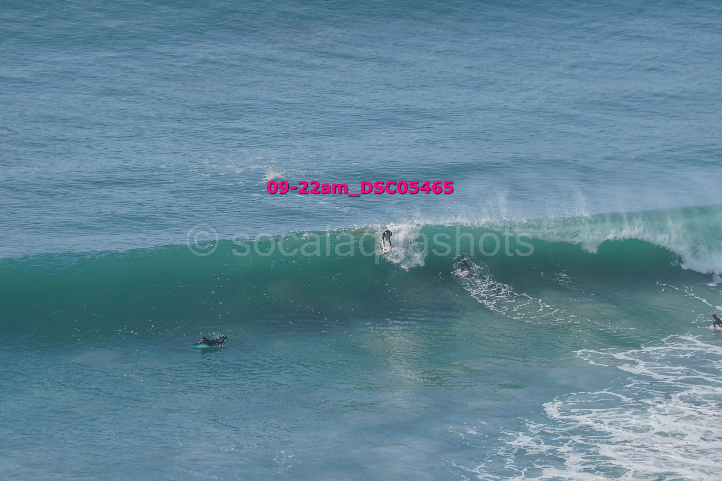 Surfers riding a large ocean wave
