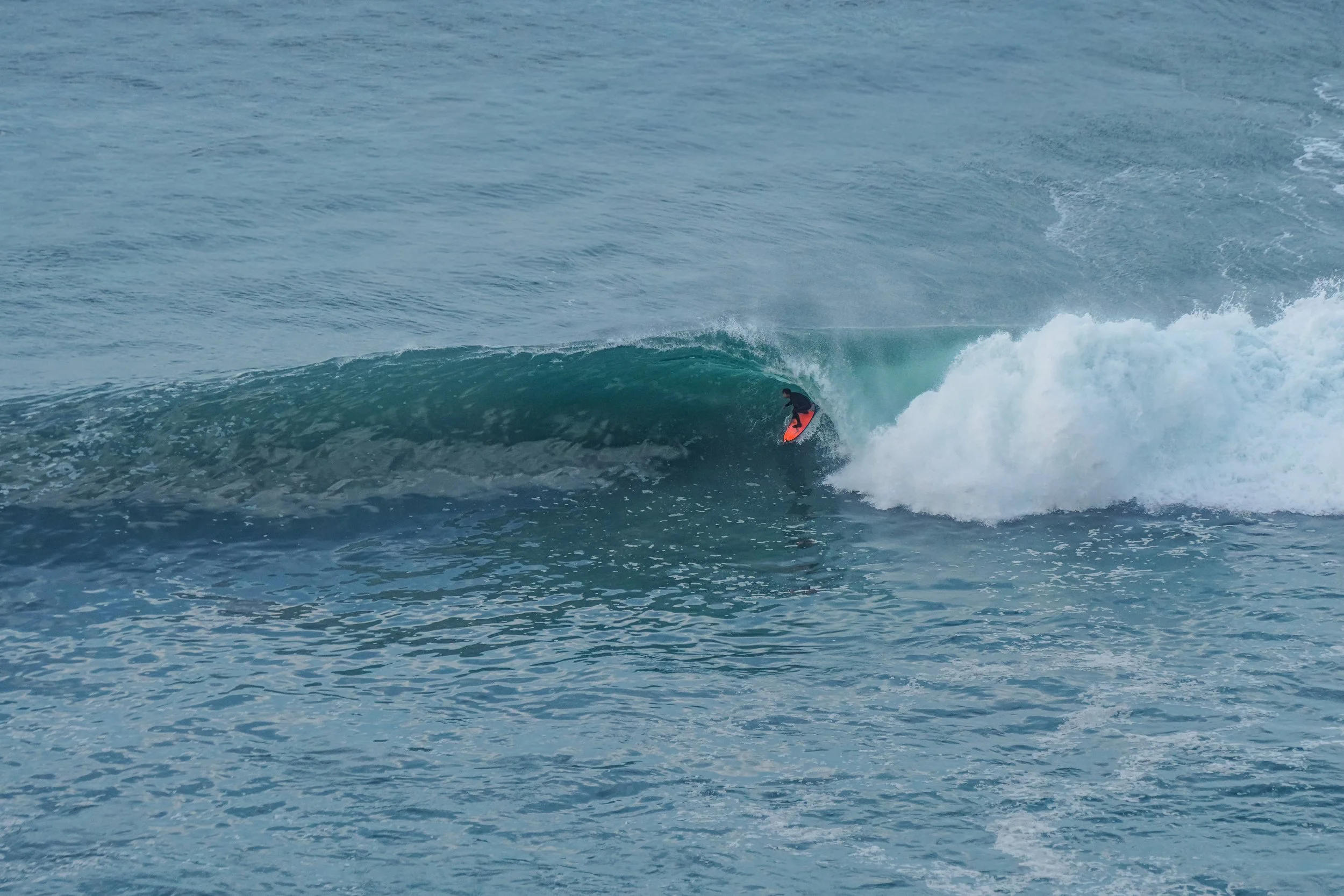 A person surfing on a wave in the ocean.