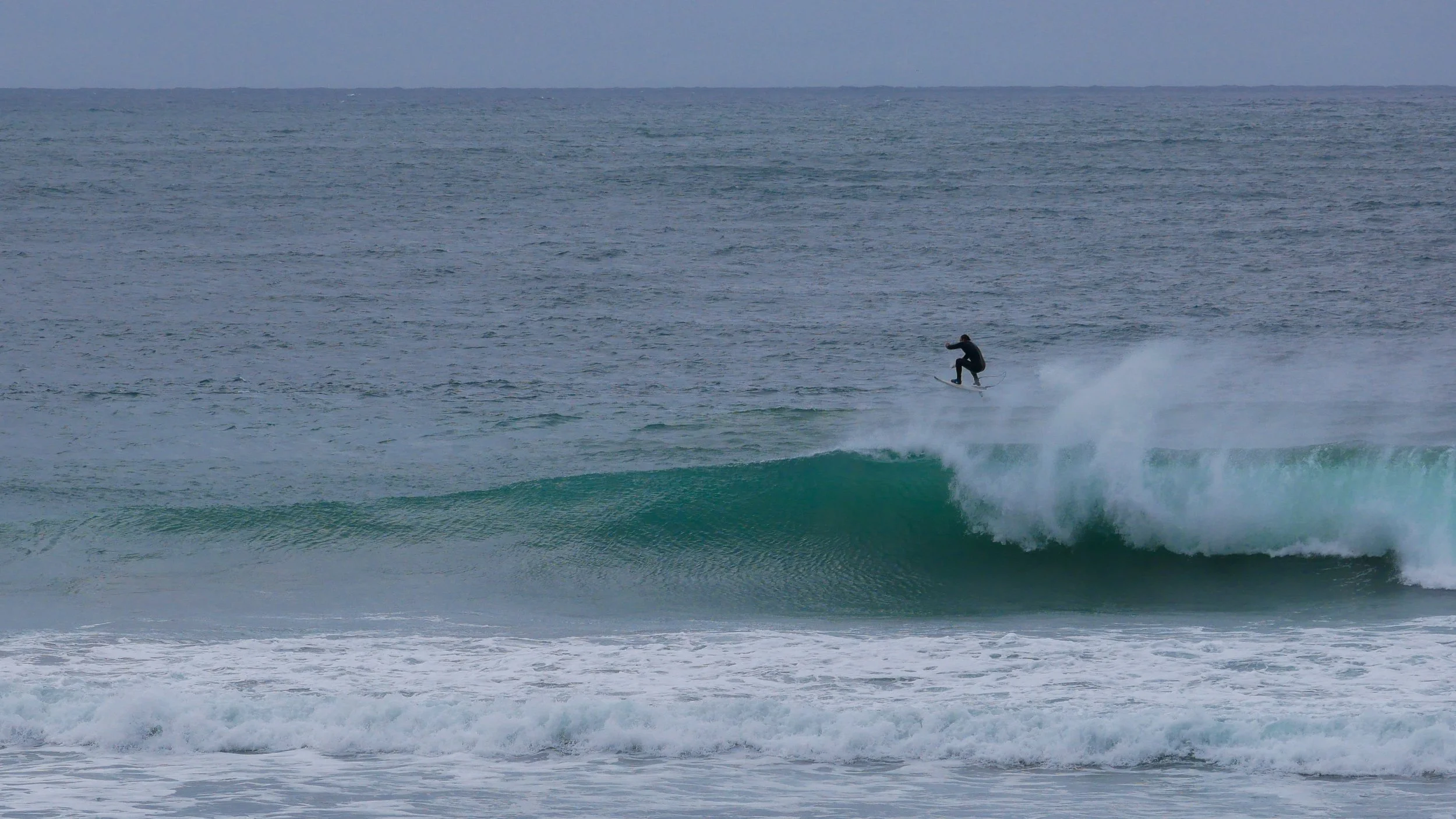 Surfer performing aerial maneuver on wave in ocean
