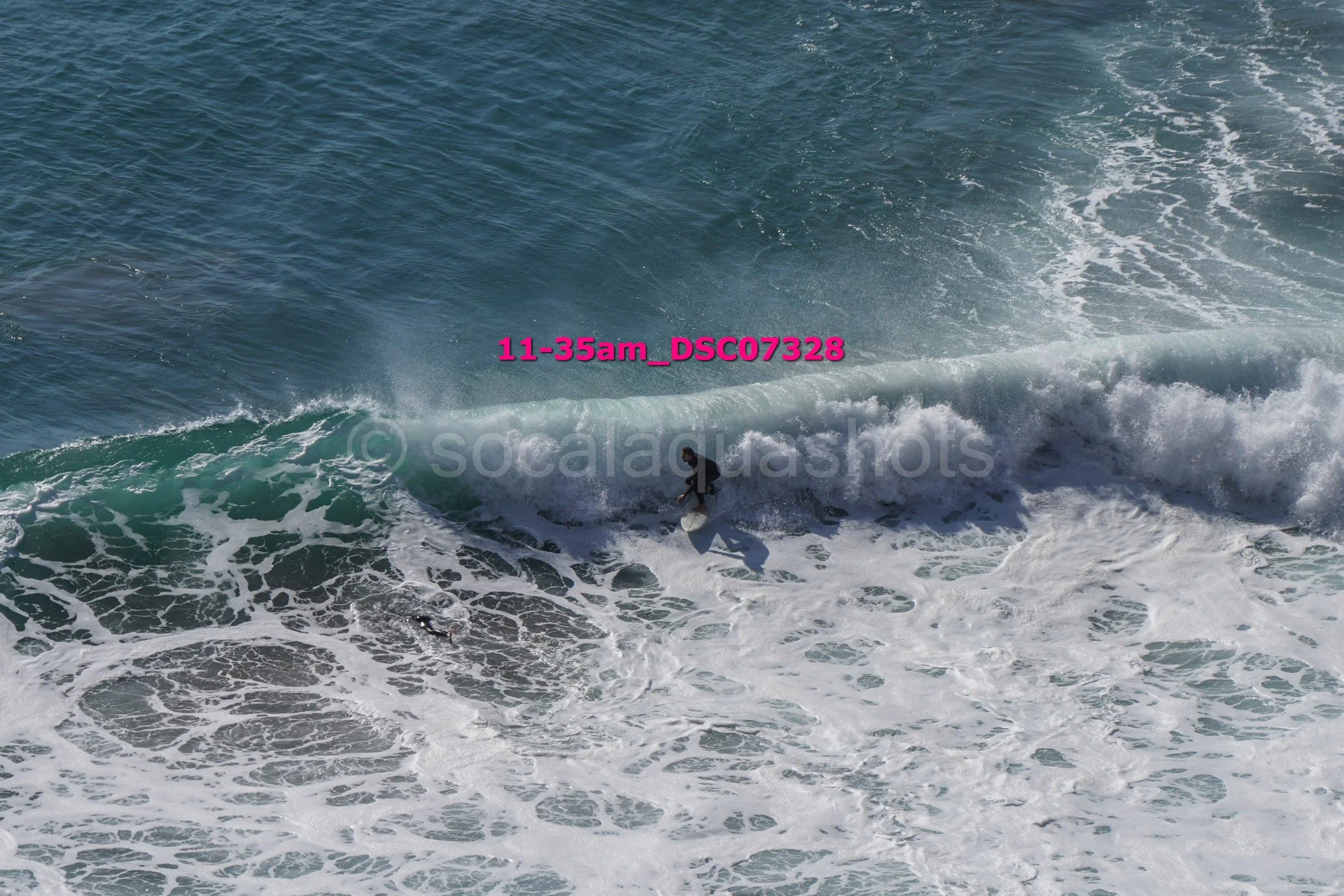A person surfing on a wave in the ocean during the daytime.