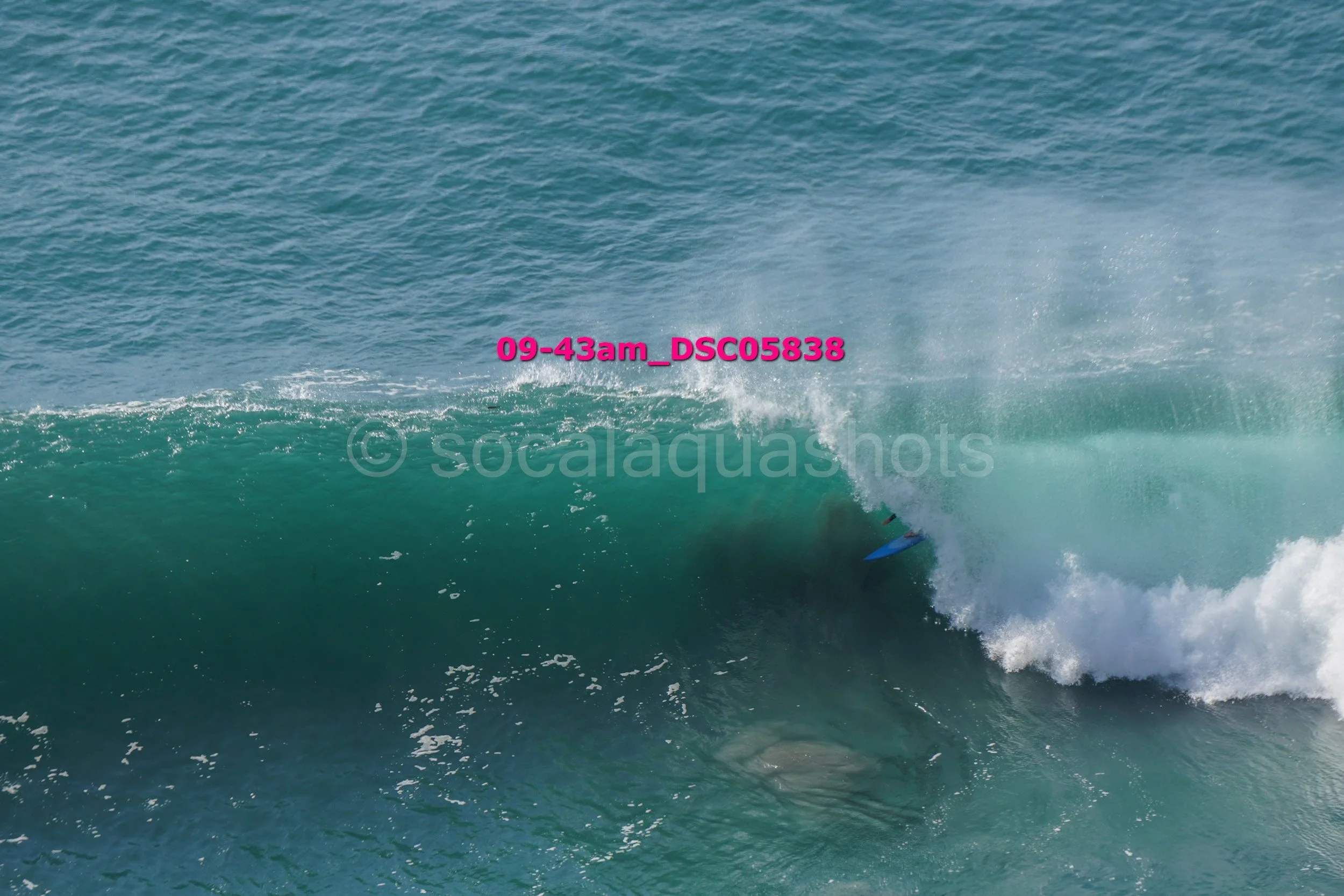 A surfer riding inside the barrel of a large ocean wave.