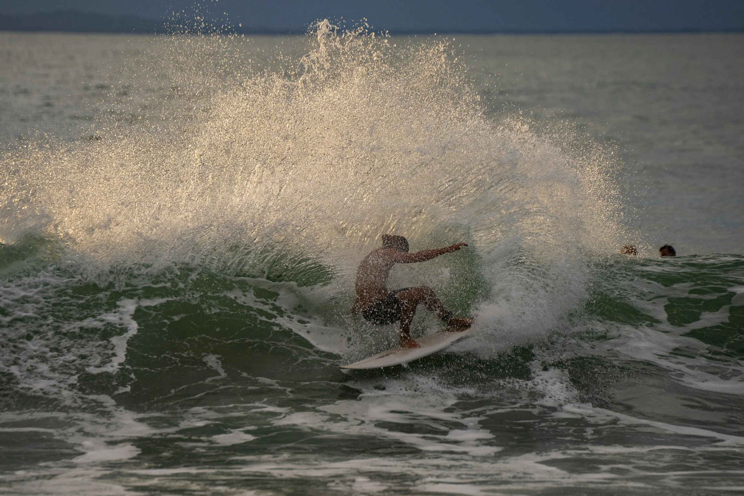 A person surfing on a wave in the ocean during daylight.