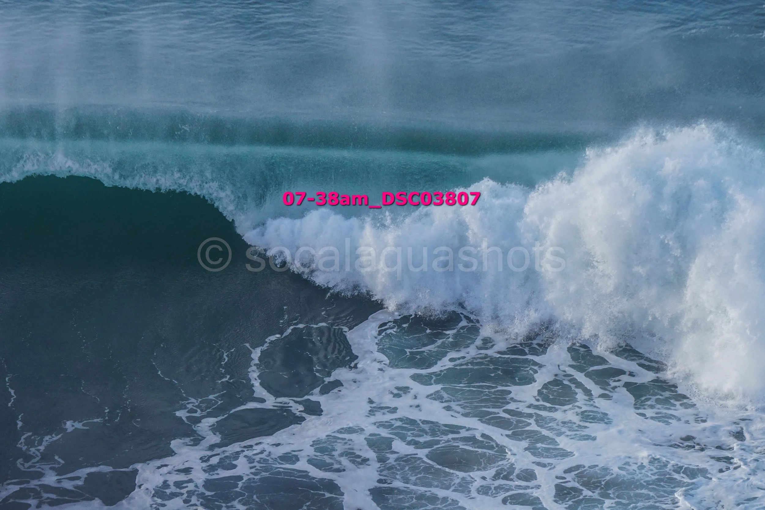 Ocean wave crashing with white foam and water spray.